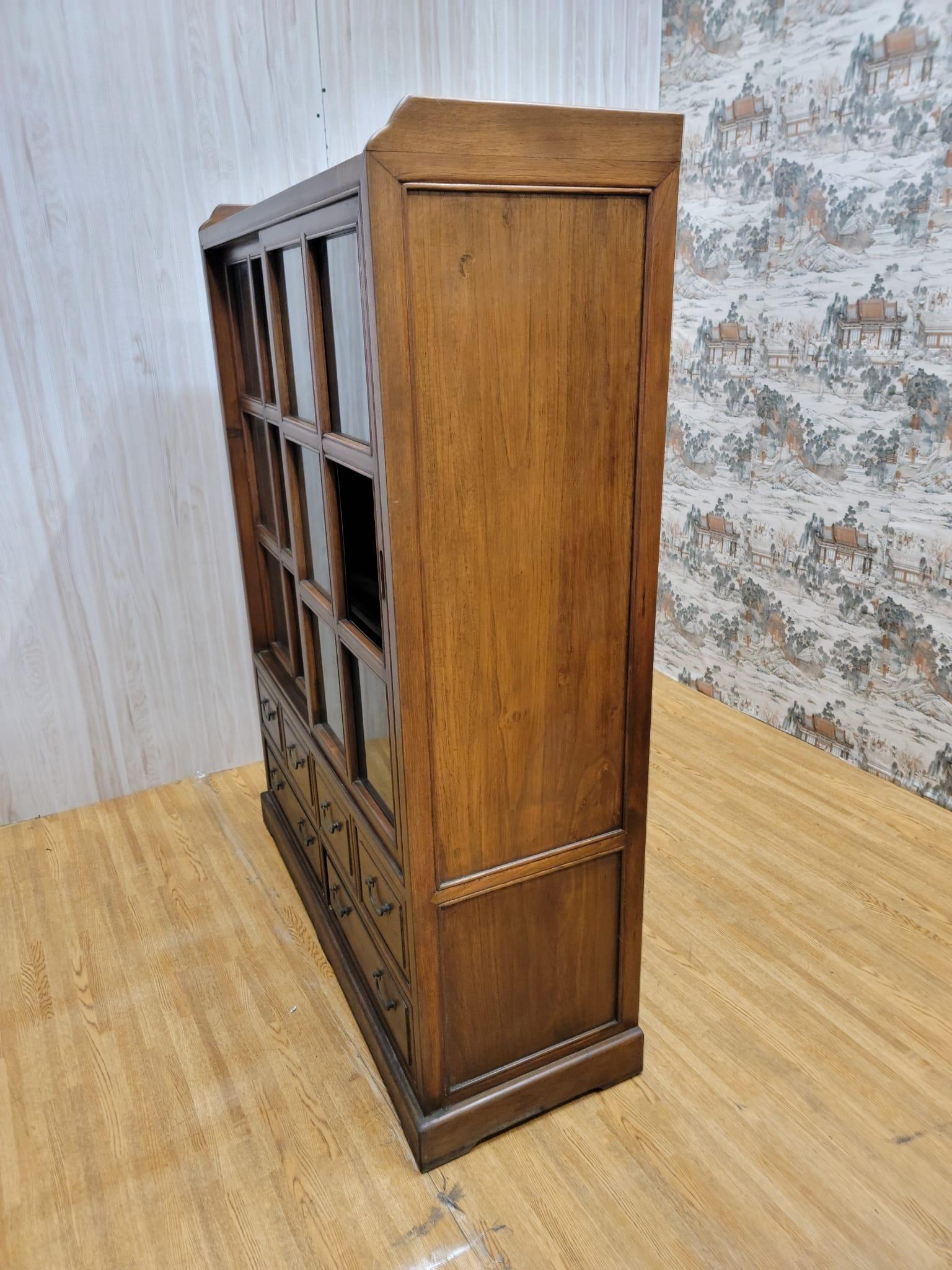 Vintage Chinese Elm display cabinets / bookcases 

These elm sliding glass cabinets that have a brown lacquer finish has 6 drawers and 3 shelves. Can be used as display cabinets or great bookcases. 

Circa: 1994

Dimensions:

W: 48