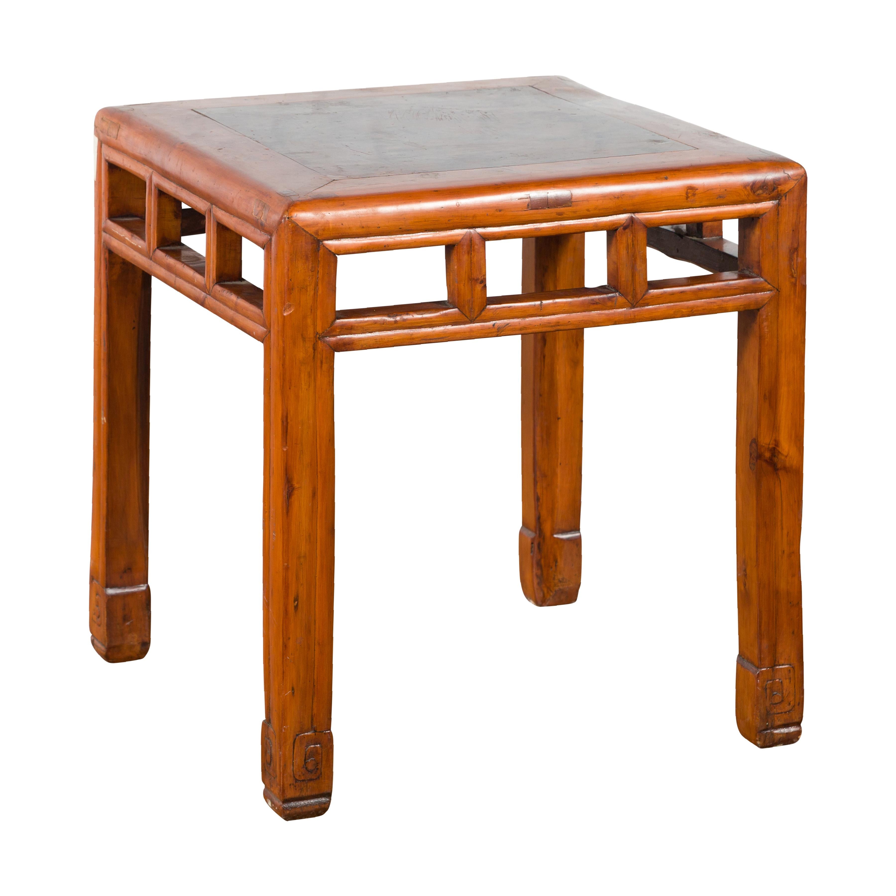 A vintage Chinese elm wood side table from the mid-20th century, with burl inset top and natural wood stain, open apron and pillar strut motifs. Created in China during the midcentury period, this vintage side table presents a linear silhouette