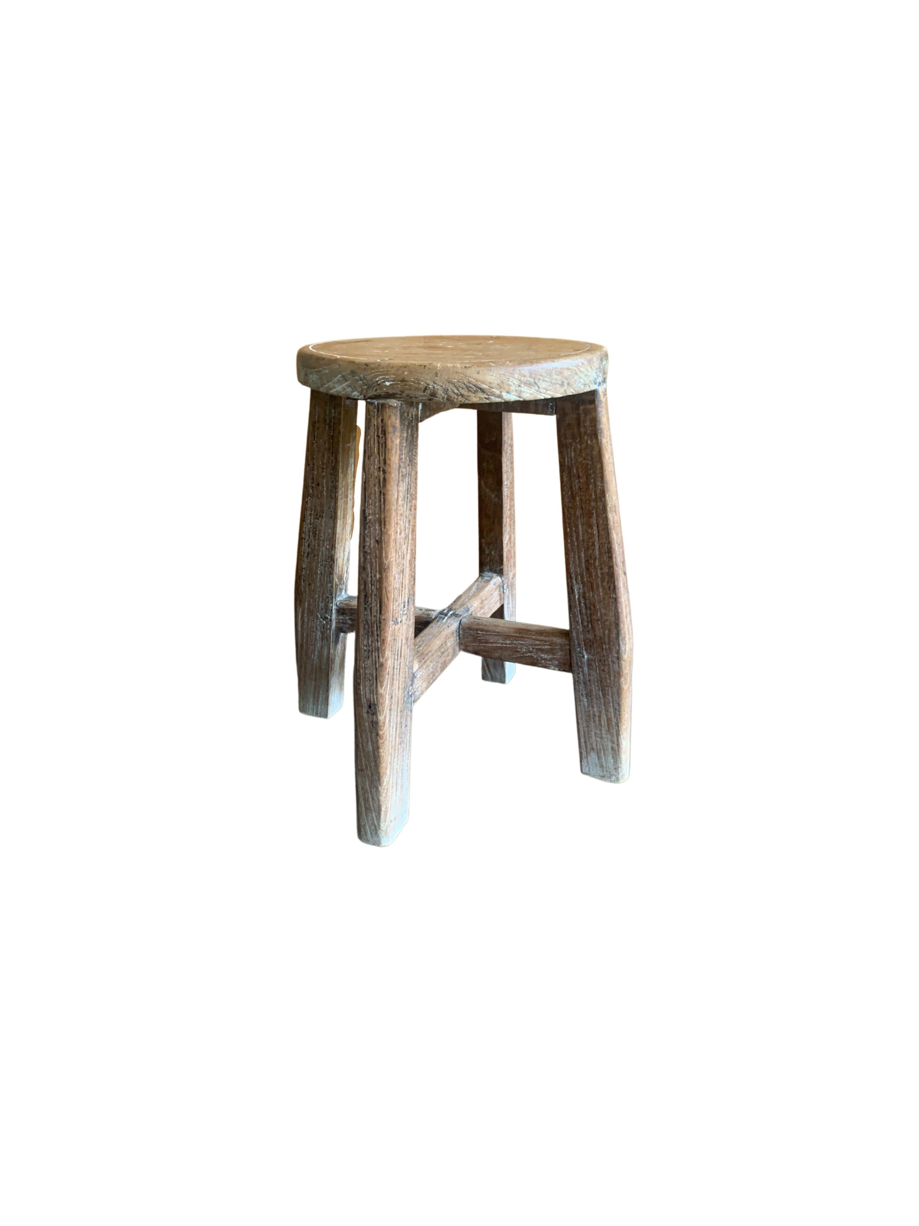 This elm wood stool comes from China's Hubei province. It was crafted using only wooden joints. This stool features three splayed and curved legs that add to its charm. The wood stool features a faded white finish and wood texture.
  