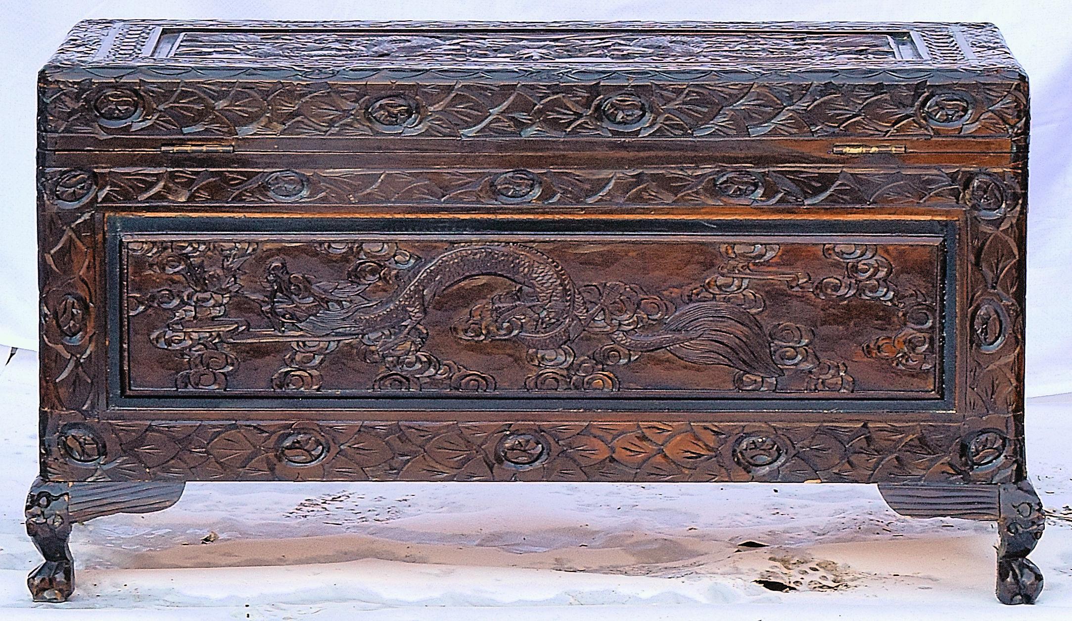 We are delighted to offer for sale this vintage Chinese export carved wood trunk with claw and ball feet with the front of the piece depicting dragon scenes, hand-hammered lock plate that has been engraved, and claw and ball feet.

circa