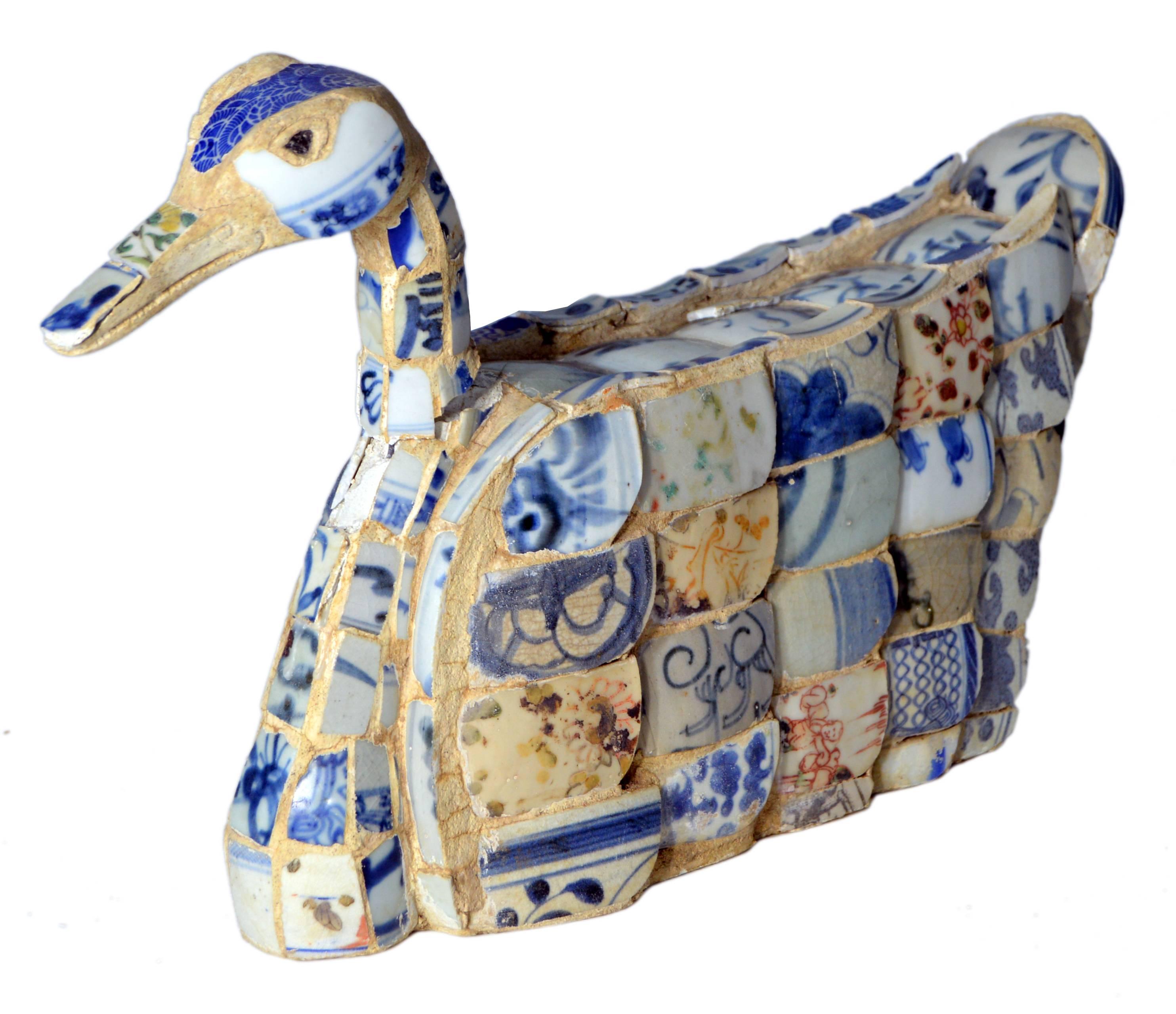 A  Chinese faience duck sculpture with blue oriental accents. Faience is tin-glazed pottery on a delicate pale buff earthenware body, a Chinese technique the Dutch copied in 17th century as part of their development of the Delftware technique. This