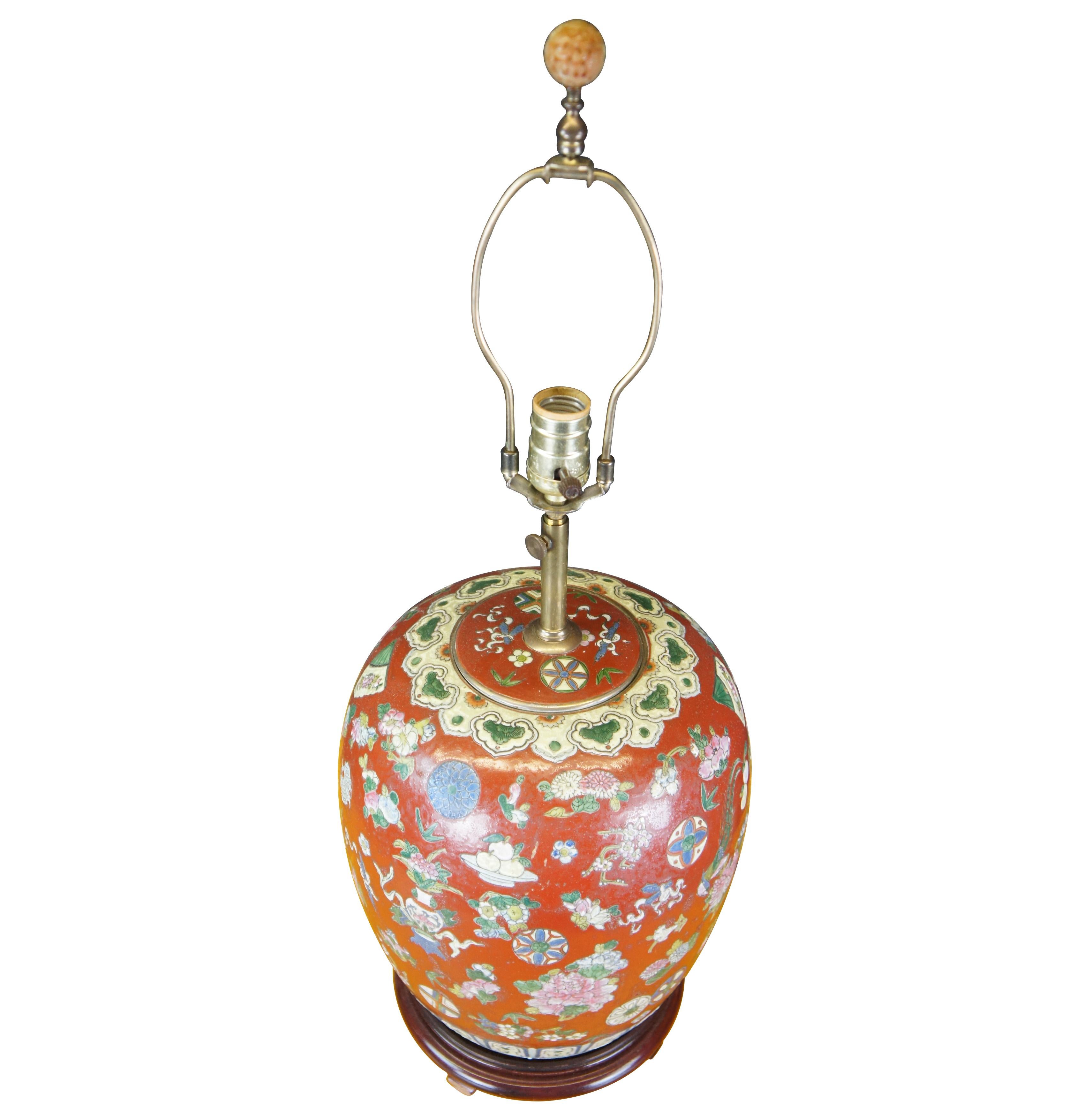 Vintage Chinese famille rose melon vase / ginger jar table lamp. A red field with floral designs over wooden base with unique finial, circa 1970s.