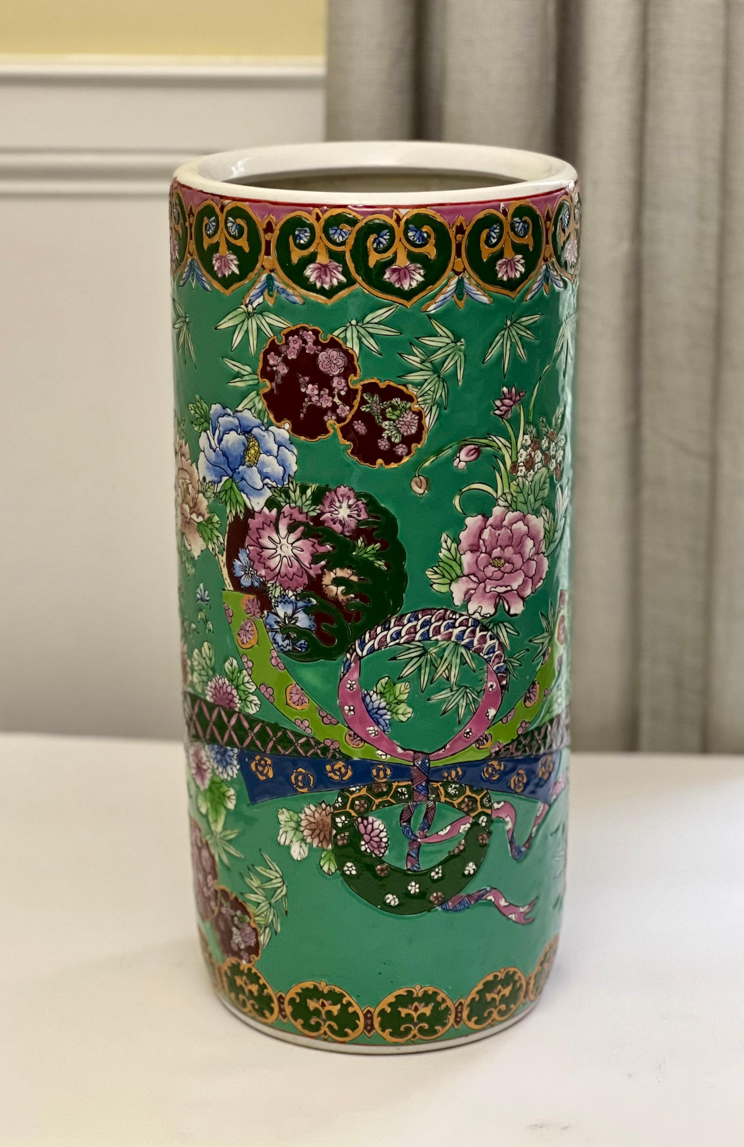 Jarrón cilíndrico o paragüero de porcelana china Famille Verte, c. 1960.

Este alegre jarrón o soporte para bastón/paraguas tiene unos colores vibrantes con flores y detalles de cintas. Marcado en la parte inferior con un sello de dinastía