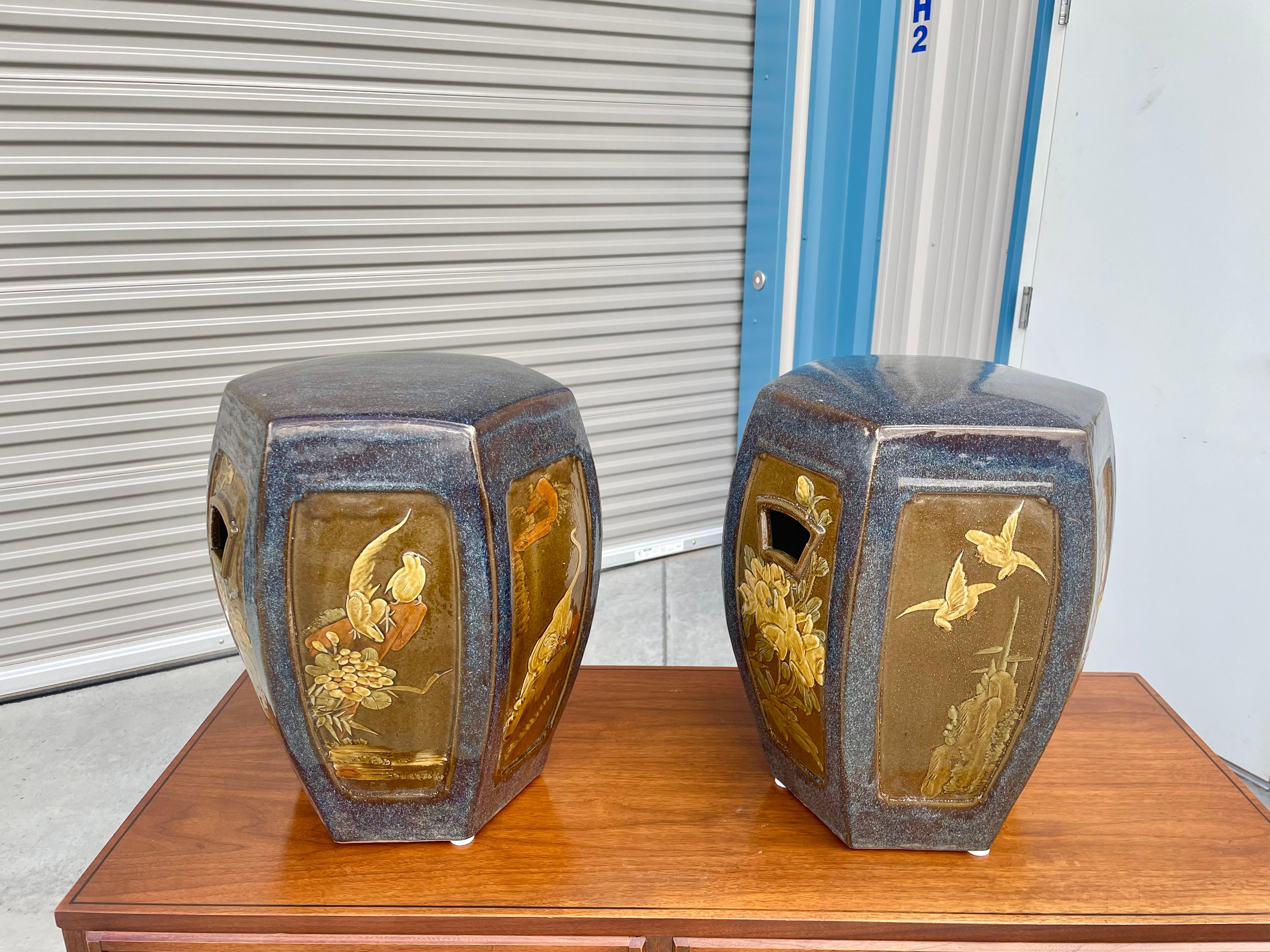 Pair of vintage Chinese stools designed and manufactured in China, circa 1970s. This beautiful pair of stools features a ceramic base with a different art design on each side. The perfect addition to your garden.