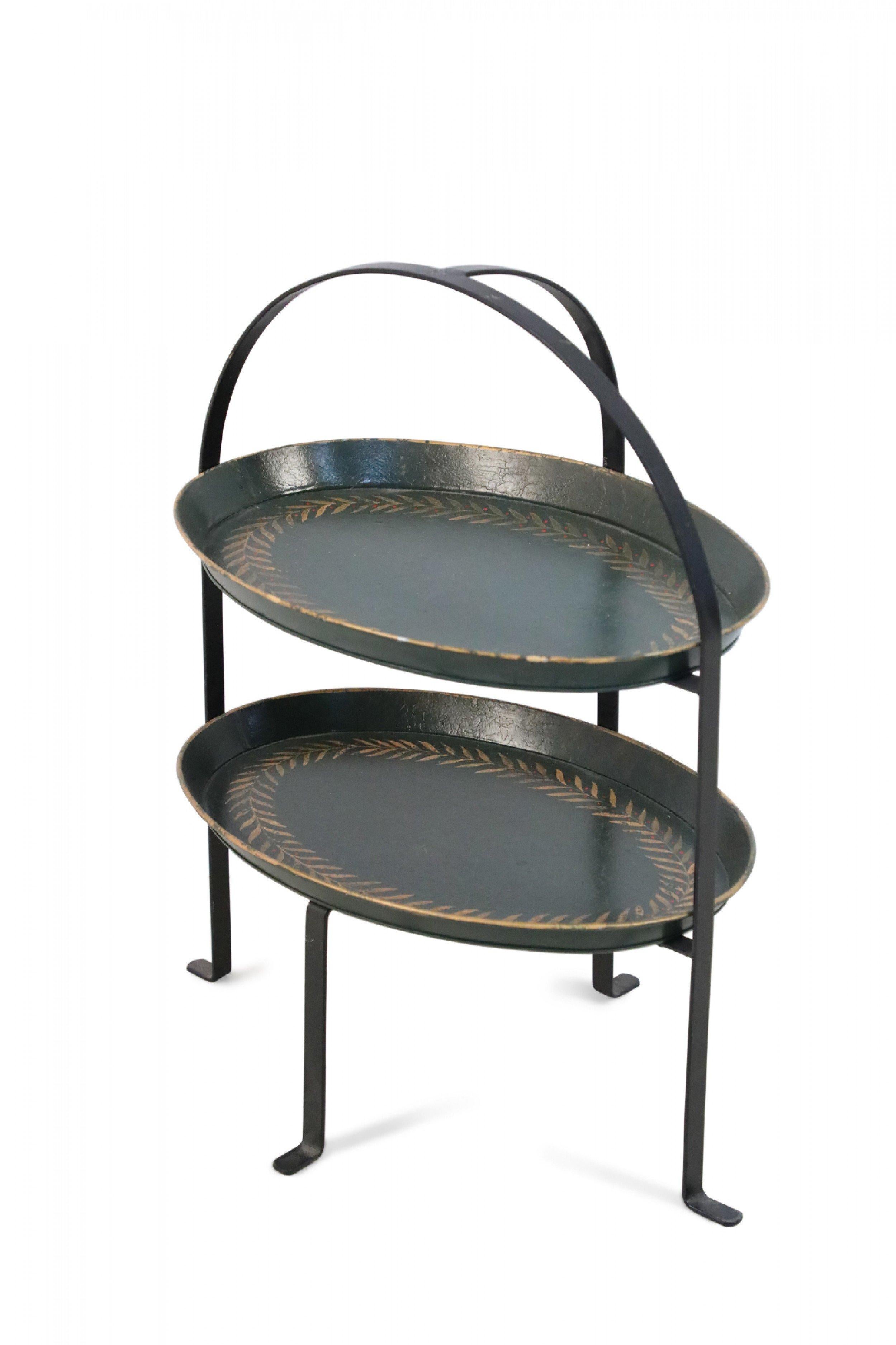 Serveur vintage chinois à deux niveaux, en tole vert foncé, avec un cadre en métal noir supportant deux étagères ovales décorées d'une bordure en guirlande de feuilles d'or avec des points rouges (Disponible en noir : NWL2451).