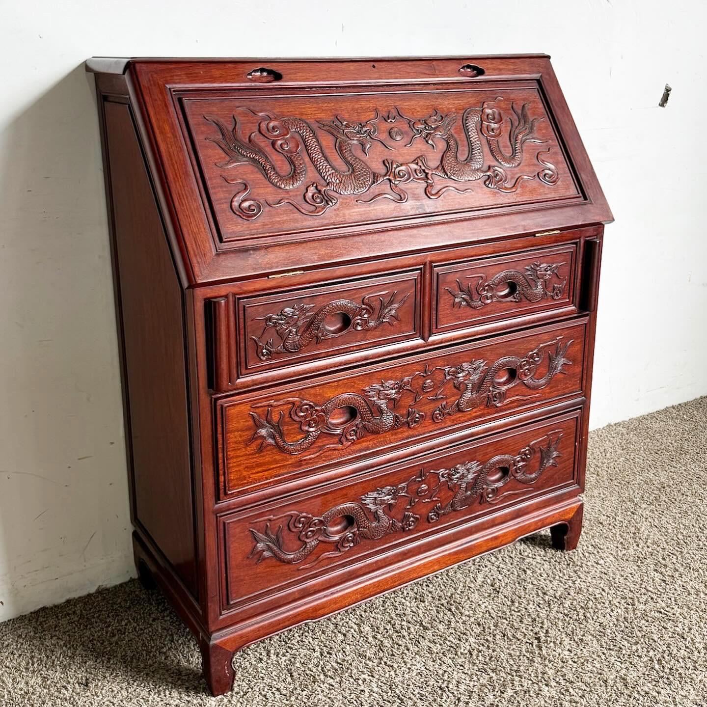 The Vintage Chinese Hand Carved Cherry Finished Secretary Desk is a masterpiece of traditional Chinese craftsmanship. Adorned with intricate dragon carvings, it features a rich cherry wood finish, enhancing its elegance. With three spacious drawers,