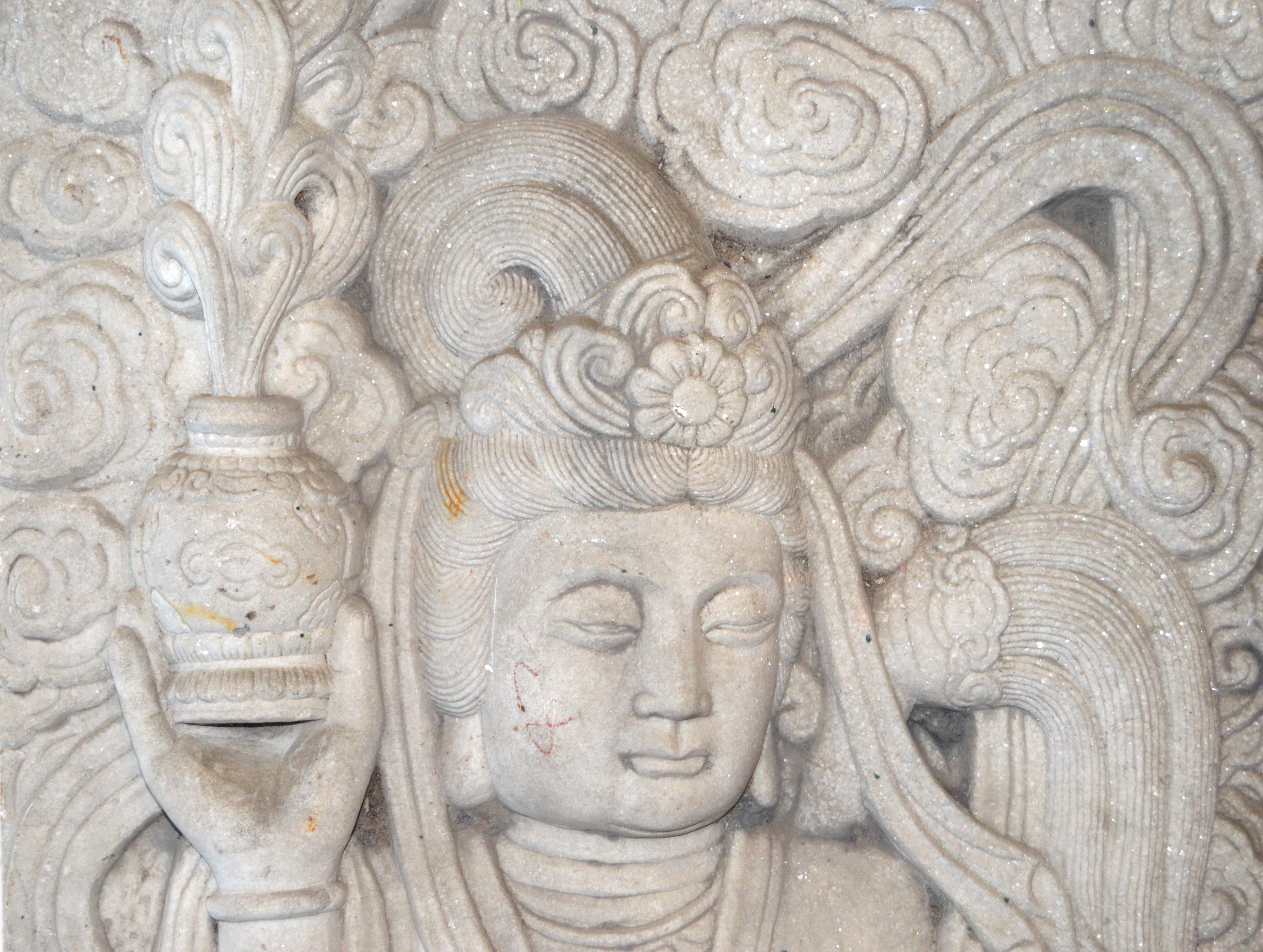A large Chinese vintage hand-carved white stone Buddhist temple sculpture of a bodhisattva. This large size Chinese sculpture was carved from a white stone and showcases a bodhisattva holding a perfume pot. A bodhisattva is someone capable of
