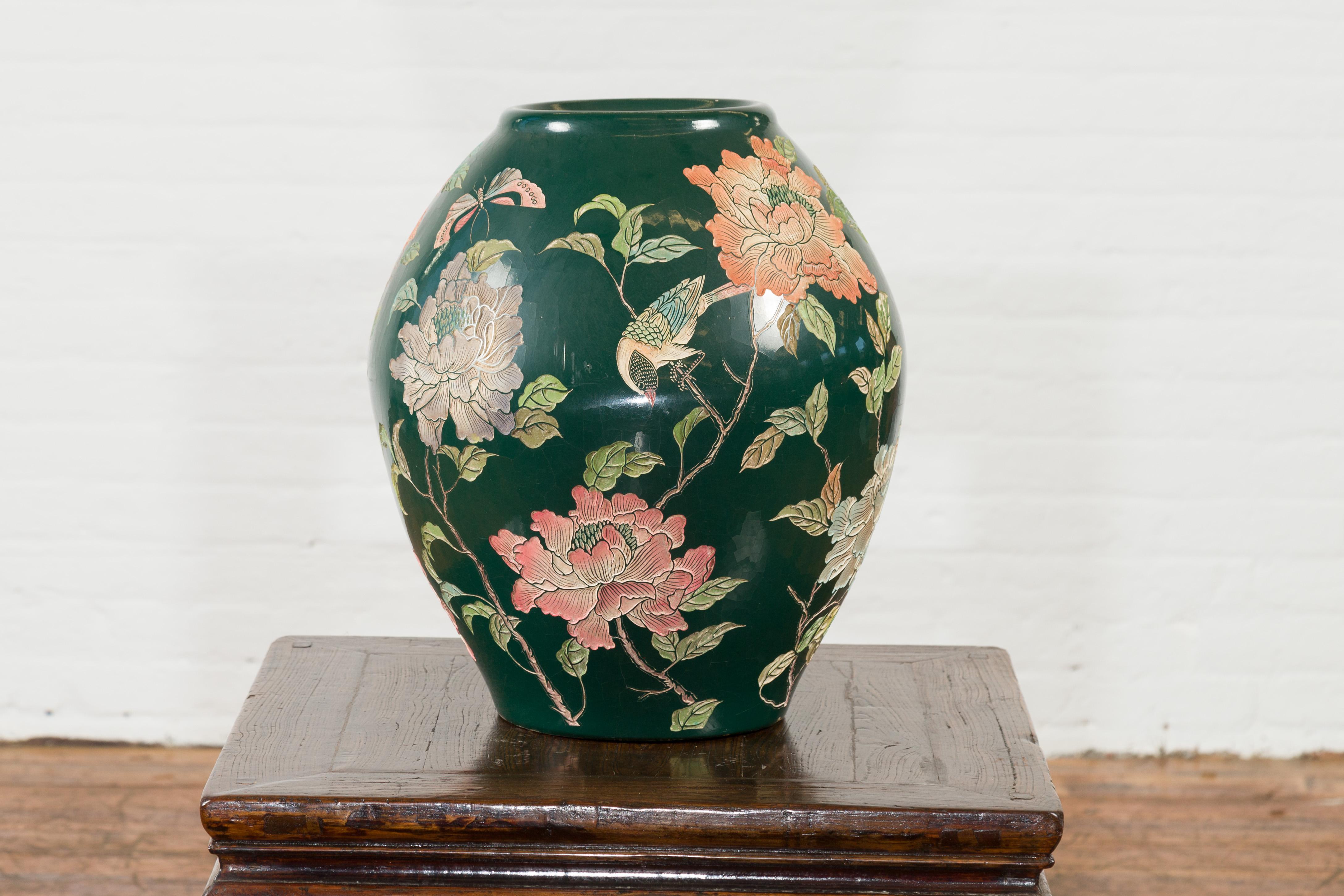 A vintage Chinese handcrafted green vase from the mid-20th century, with incised floral and bird decor. Created in China during the midcentury period, this vase features a dark green ground perfectly accented with a delicate incised decor showcasing