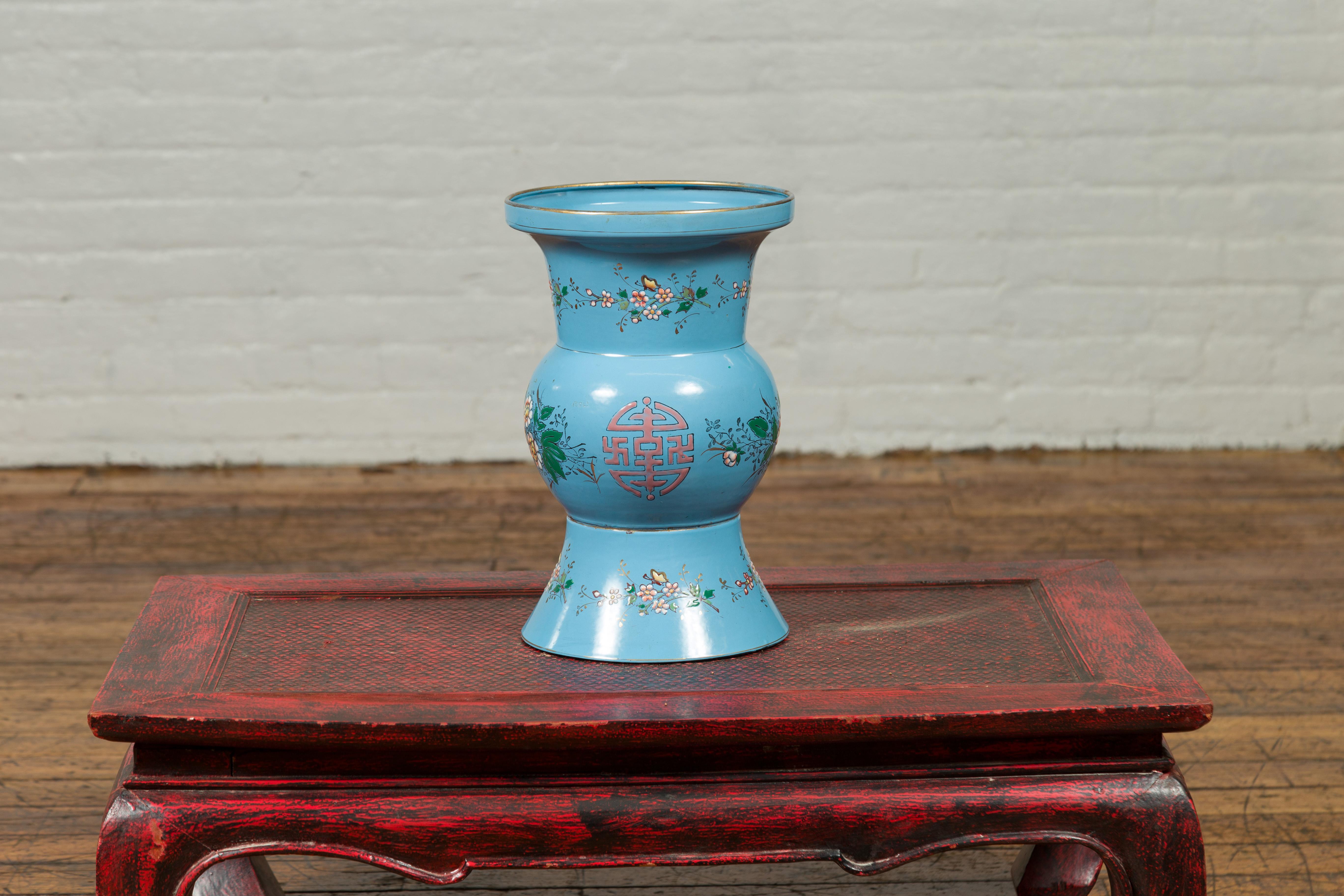 A vintage Chinese hand painted blue metal vase from the mid-20th century with calligraphy and floral décor. Crafted in China during the midcentury period, this charming vase attracts our attention with its soft blue ground accented with calligraphy