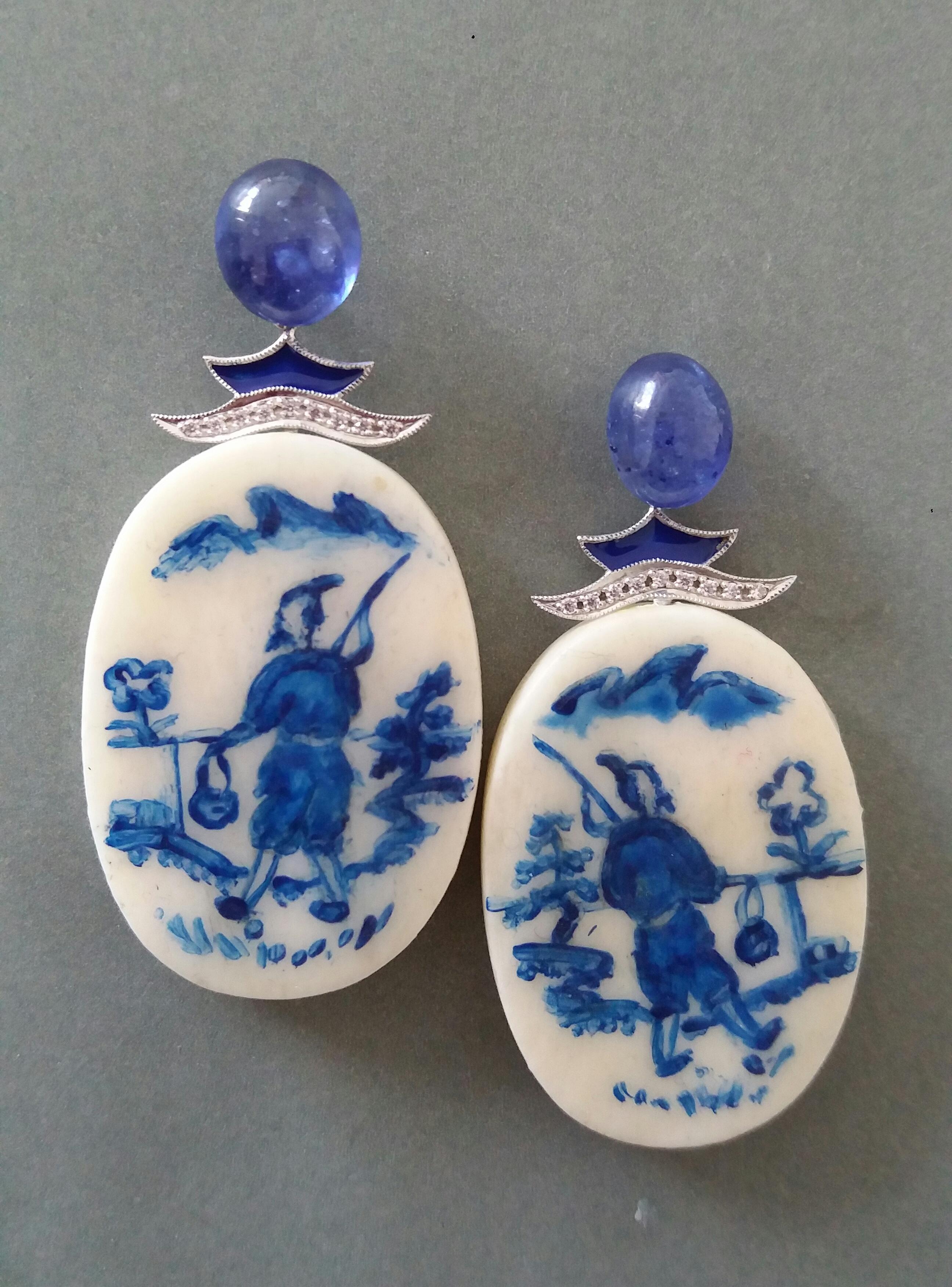 Vintage pair of oval shape hand painted cow bones flat drops depicting  a chinese fisherman walking near the river ,suspended from 2 oval Blue Sapphire  cabochons size 8x10 mm ,in the middle we have 2 white gold parts with diamonds and blue