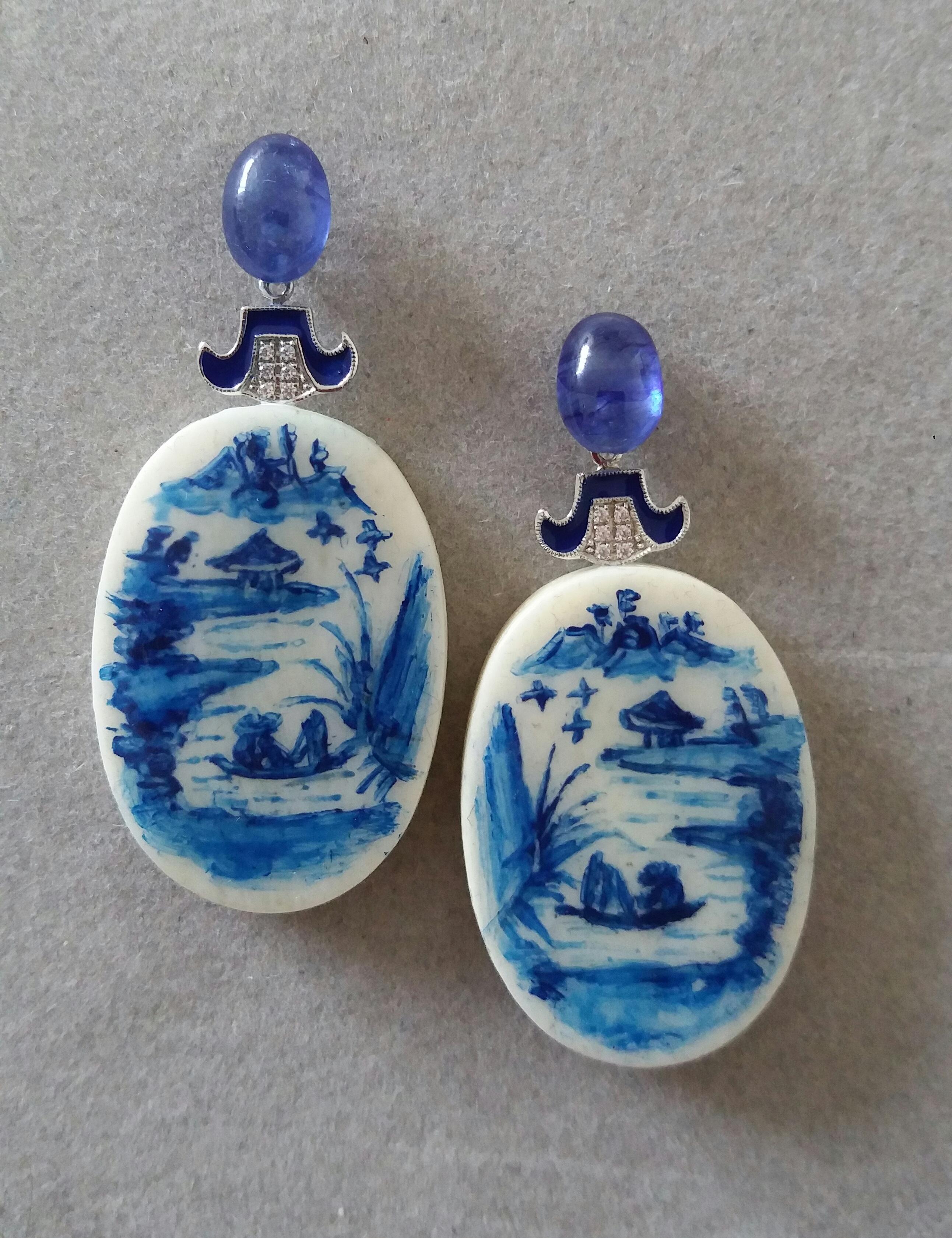 Vintage pair of hand painted oval shape cow bones  depicting  a lake landscape with mountains and a temple in the background and 2 chinese fishermen on their boat ,suspended from 2 oval Blue Sapphire  cabochons size 8x10 mm ,in the middle we have 2