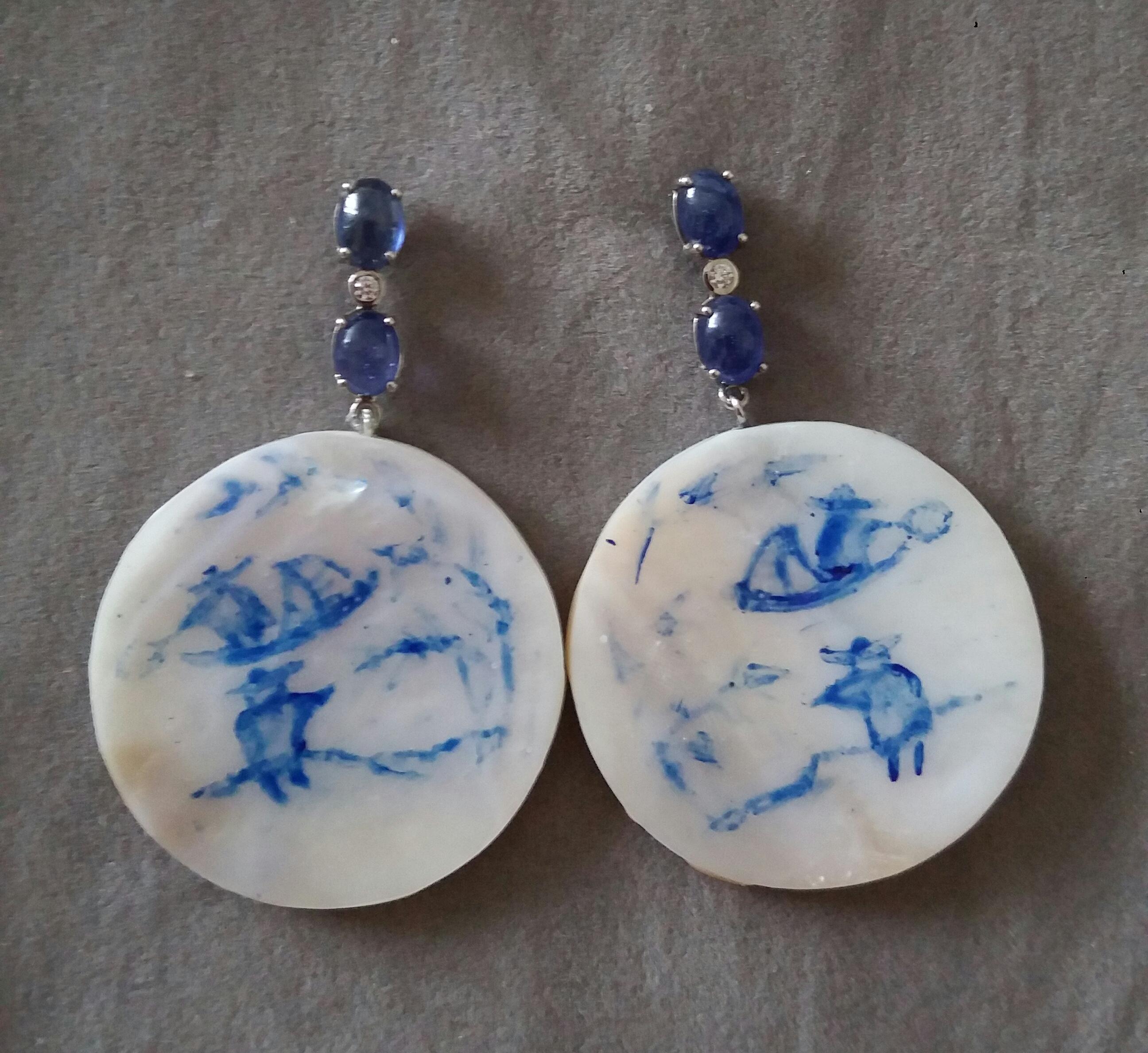 Vintage pair of round shape hand painted Mother of Pearl discs depicting a chinese landscape,2 fishermen and a boat on the river,suspended from a gold bar composed by 2 Oval Blue Sapphires and a diamond in the middle.

In 1978 our workshop started