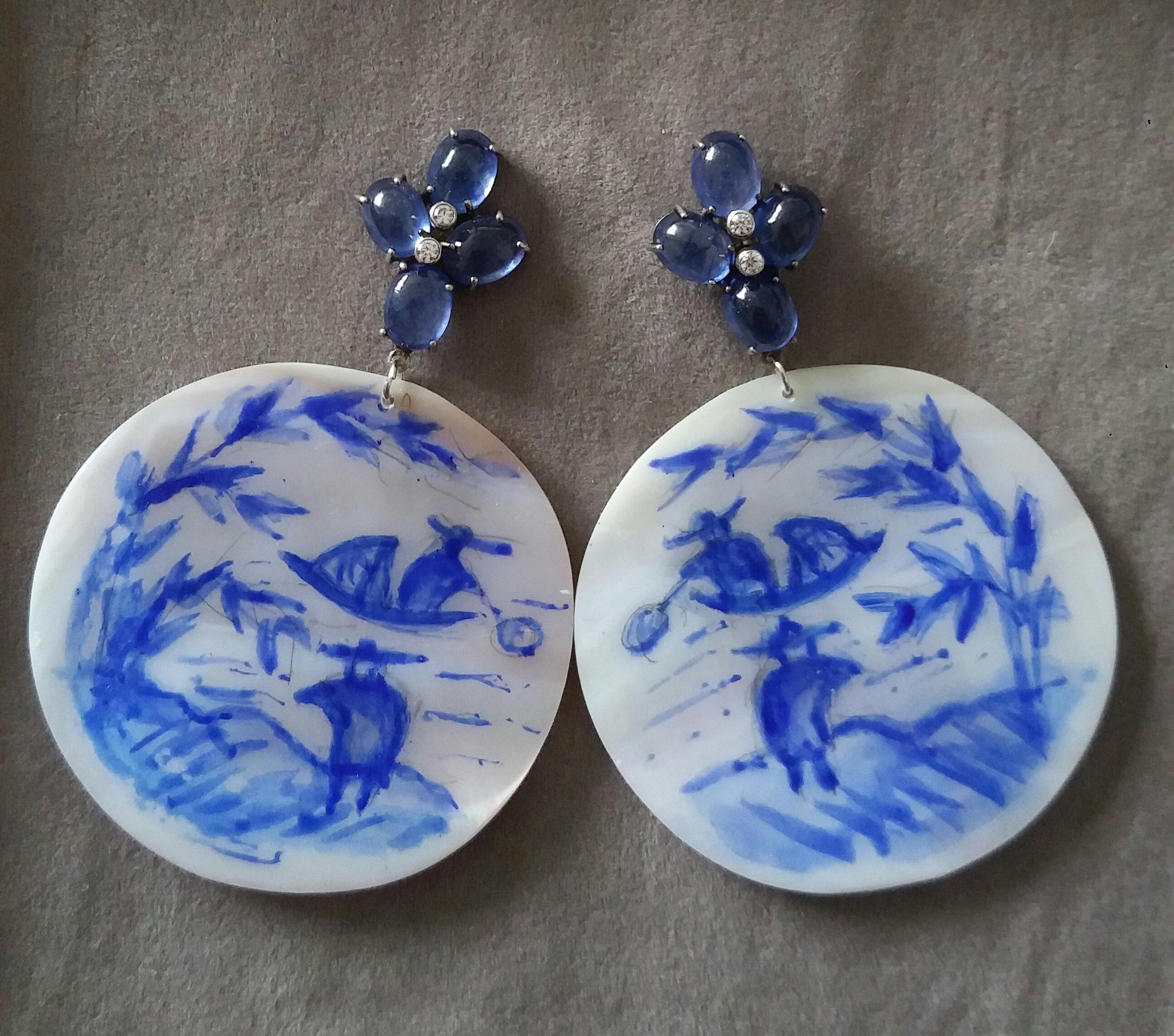 Vintage pair of round shape hand painted Mother of Pearl  discs depicting  a chinese landscape,2 fishermen and a boat on the river ,suspended from  4 Blue Sapphires Oval Cabs 6x8 mm set in white gold and with 2 small full cut diamonds in the middle