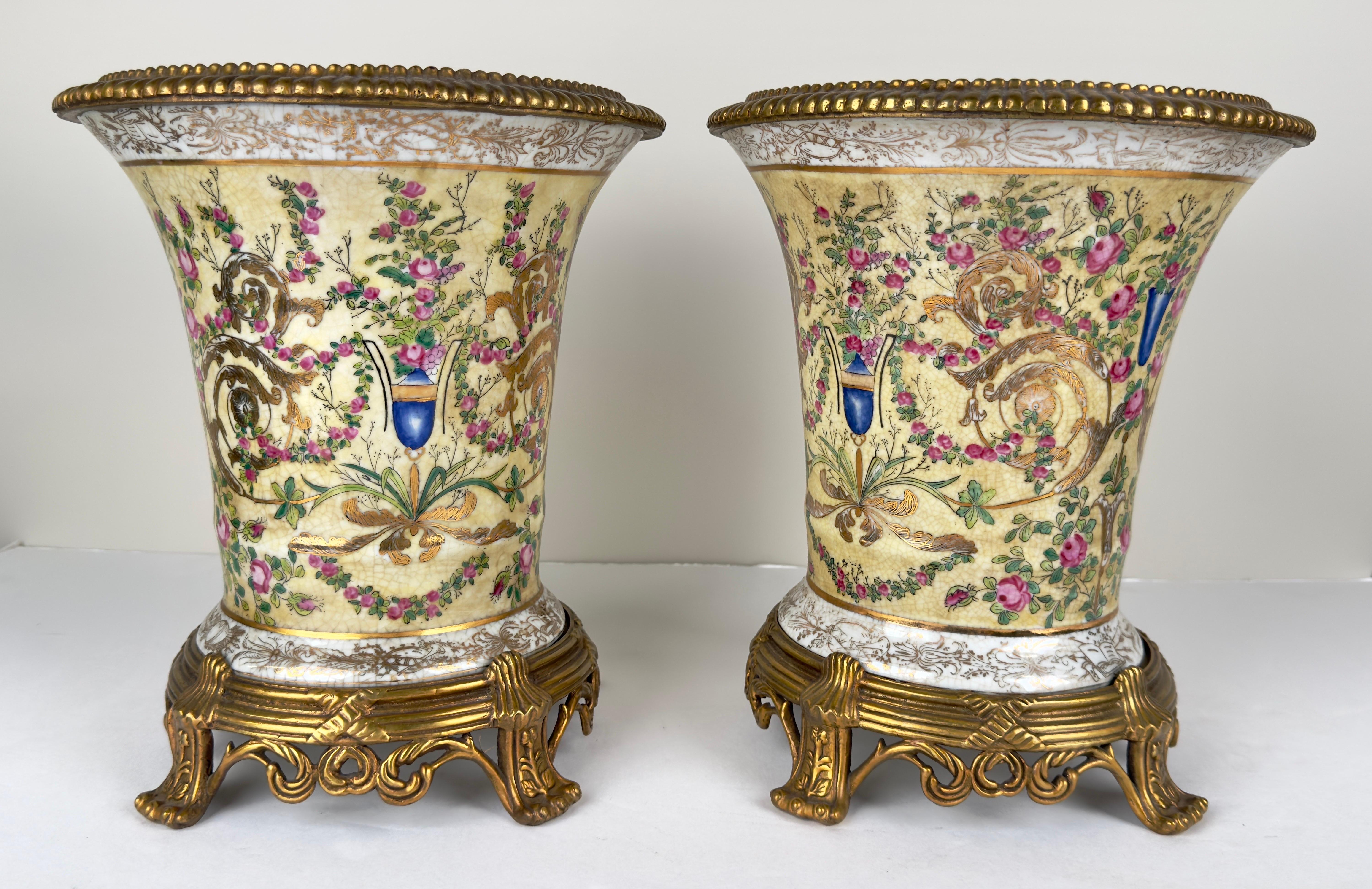 A pair of decorative contemporary Chinese porcelain vases or planters made of porcelain and beautifully hand painted.  The vases feature a bronze fluted rim and a crackle glaze finish porcelain,  a popular technique in Chinese ceramics that gives