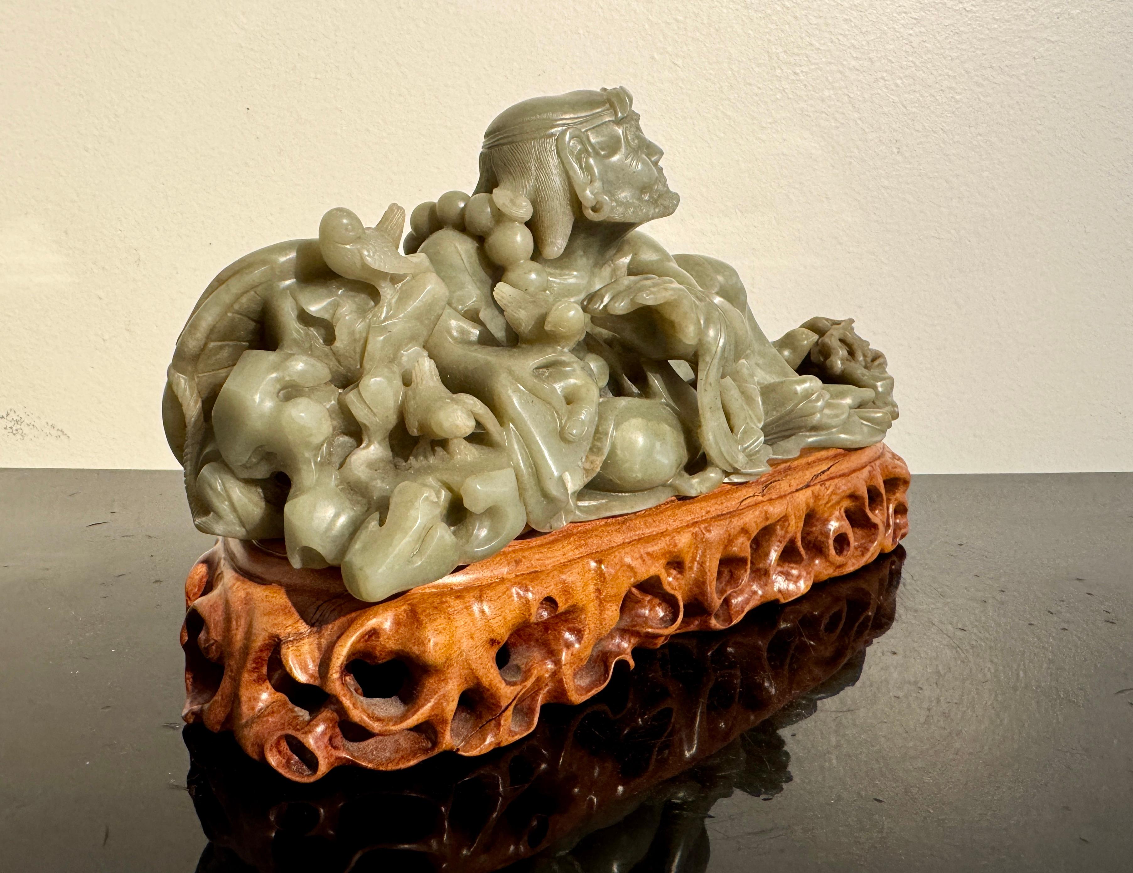 A wonderful vintage to near antique Chinese nephrite jade carving of Damo (Bodhidharma), with an associated carved hardwood stand, early to mid 20th century, possibly Republic Period, China.

The sculpture depicts Bodhidharma, known as Damo in