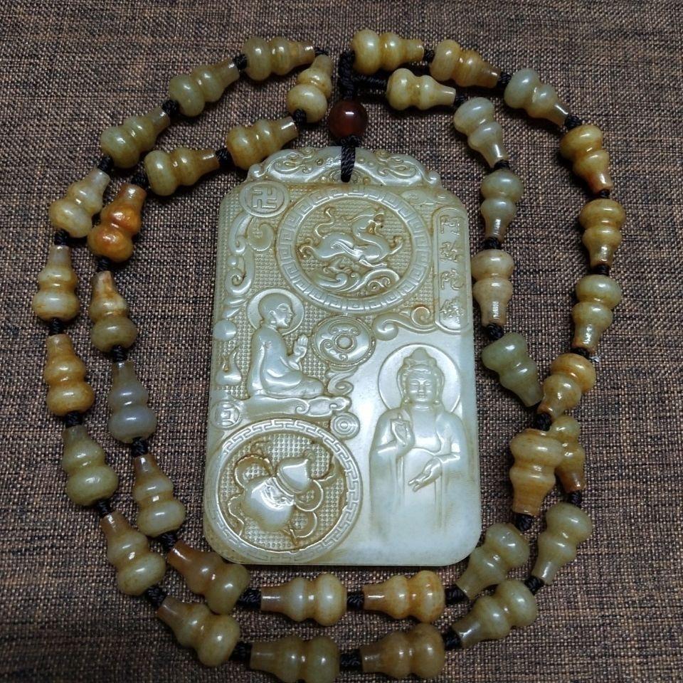 This Vintage Chinese Hetian Jade Carved Buddha Pendant paired with a Gourd Bead Necklace is a beautiful blend of spiritual symbolism and traditional craftsmanship. The pendant is meticulously carved from fine Hetian jade, renowned for its smooth