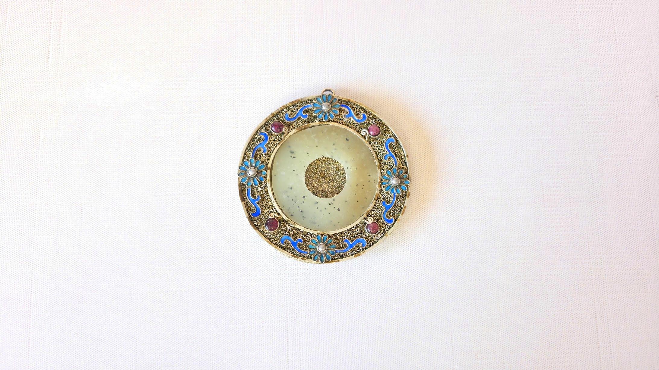 Disque bi en jade Hetian chinois vintage dans un cadre en émail argenté avec rubis et perles, dynastie Qing

Un Hetian Jade Bi chinois est un ancien disque de jade circulaire avec un trou central. Historiquement, il symbolisait les cieux et était