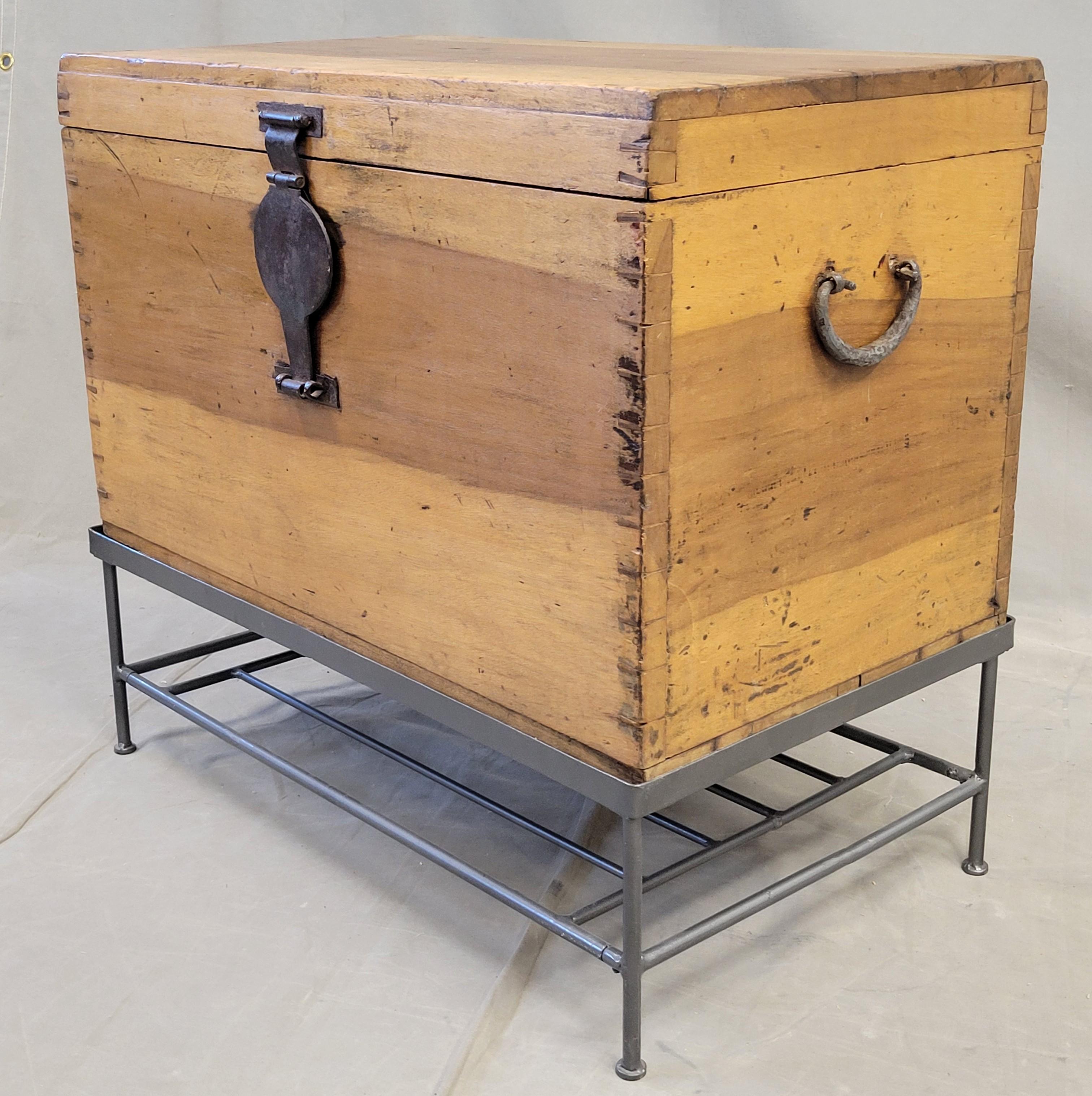 A beautiful old natural wood box with iron hardware in the Chinese style, but created in Indonesia. Note the gorgeous dovetail construction at the corners and the stunning wood grain. The interior is fitted with trays and compartments. The box sits