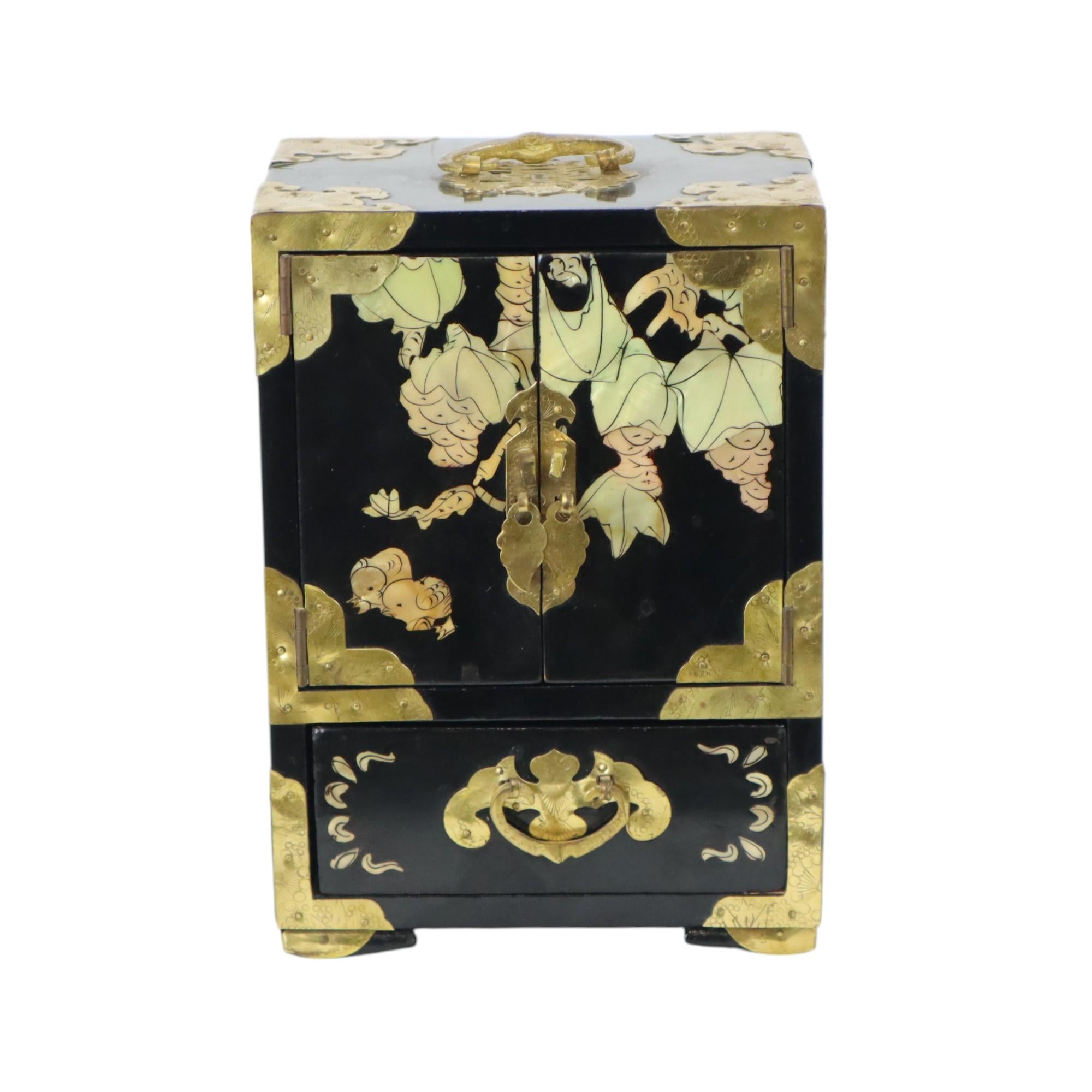 Vintage Chinese jewelry box, jewelry box with drawers and doors, black lacquered wood inlaid with mother of pearl and finished with brass fittings, inside lined with a red fabric with gold floral embroidered decoration, marked on the back Made in