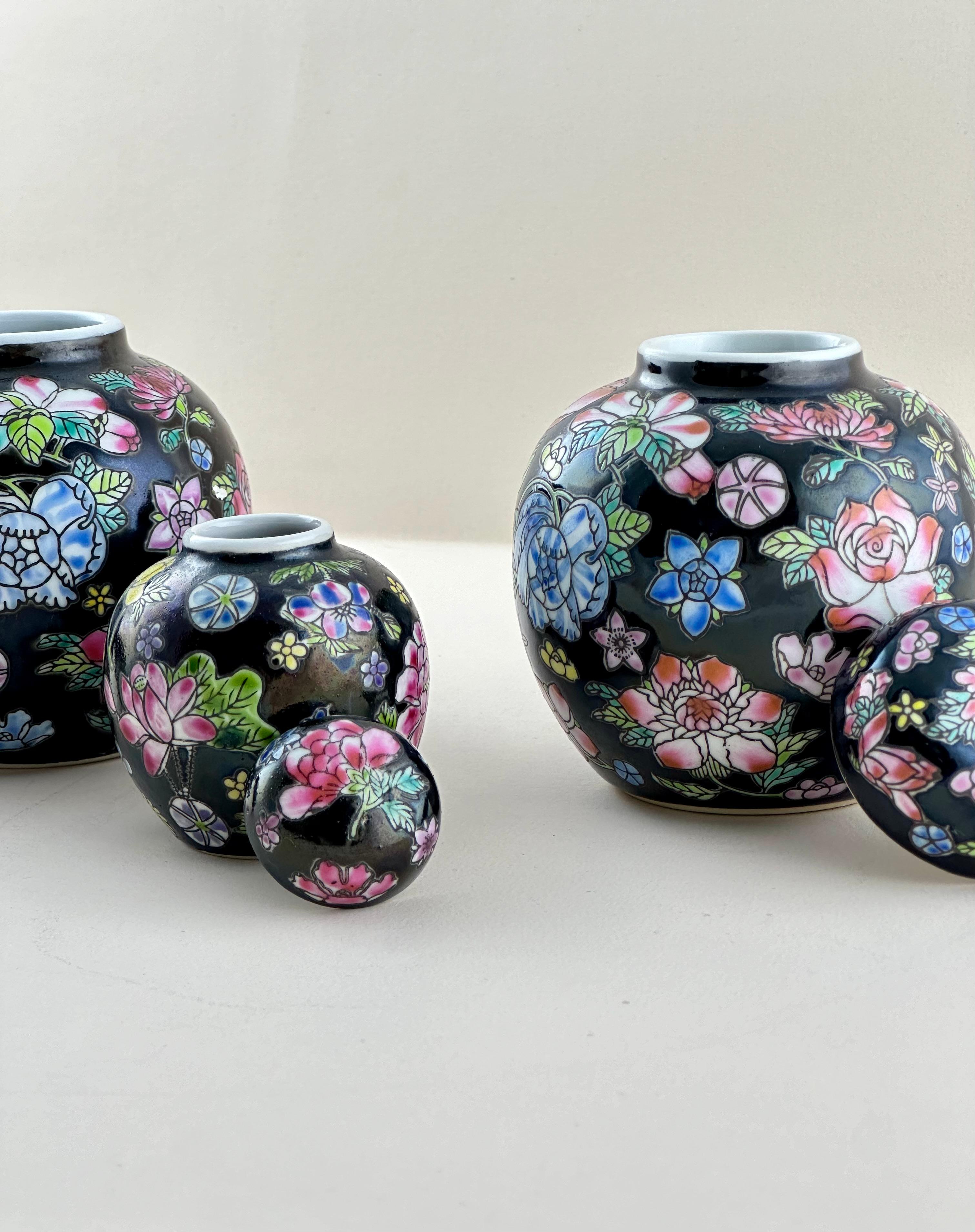 A set of three small vintage ginger jars crafted in the Jingdezhen region of China in the 1970s.

This miniature trio is decorated in the ‘Famille Noire’ style, a style originating from the Kangxi era of the Qing Dynasty. The Chinese porcelain jars