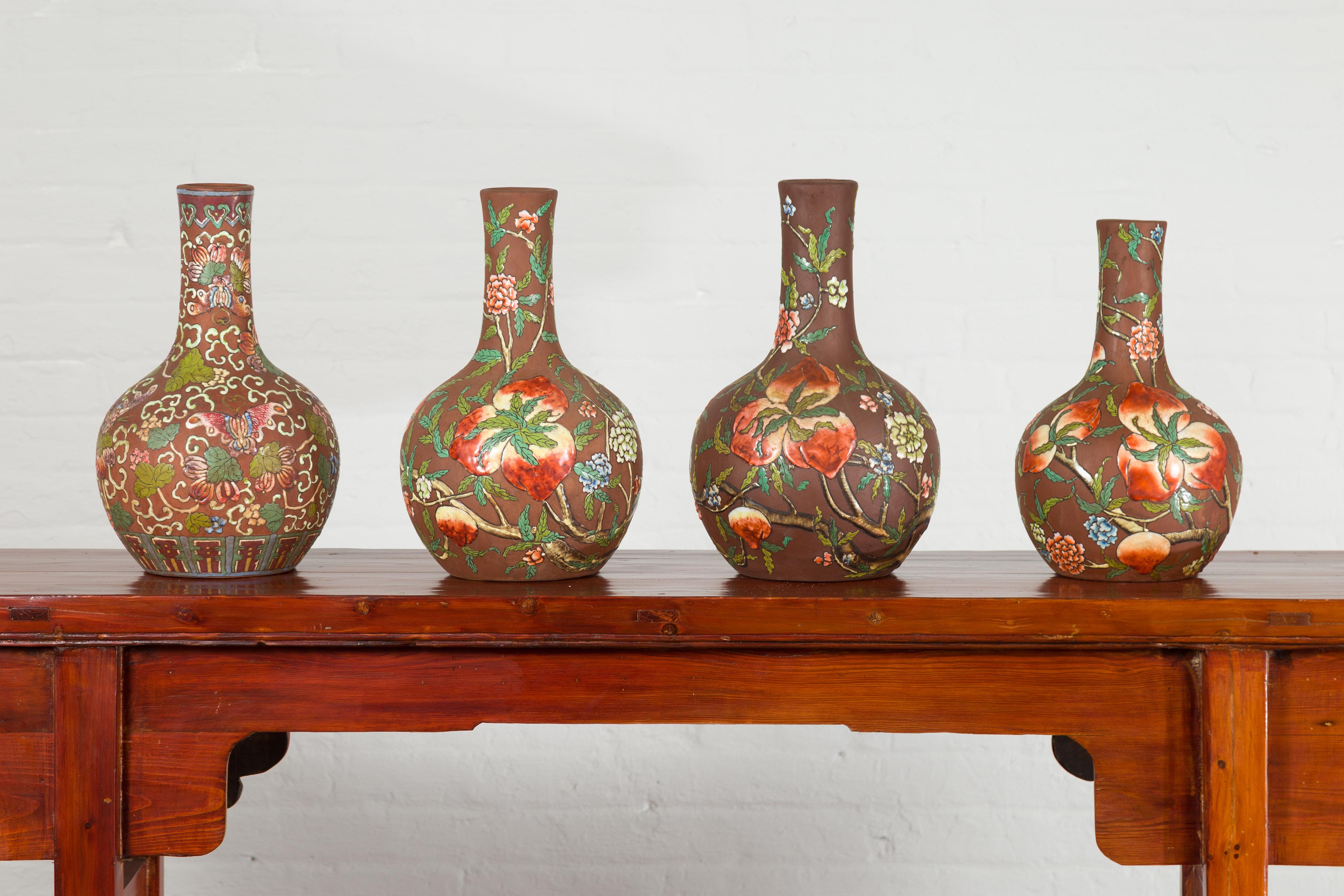 A set of four Chinese vintage Kendi shape handmade vessels from the mid-20th century, with raised fruit and flower motifs. We currently have four available, priced and sold each $750. Created in China during the mid-century period, these Kendi