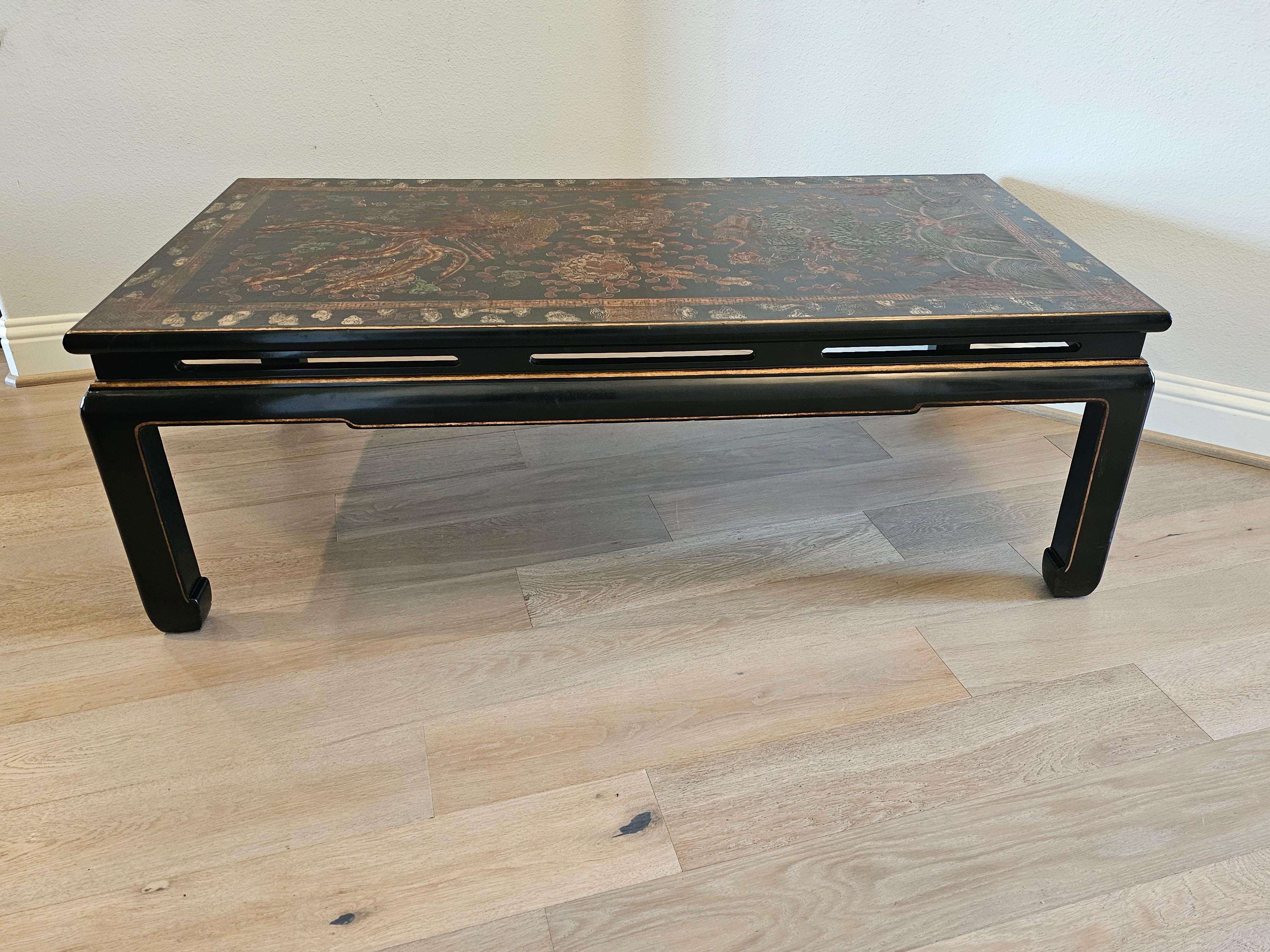 A stunning large vintage Chinese Ming Dynasty style coffee table, 20th century, in black lacquer with gilt accents, and intricate colorful hand painted and incised design to the rectangular top, depicting mythical scence of Chinese dragon and