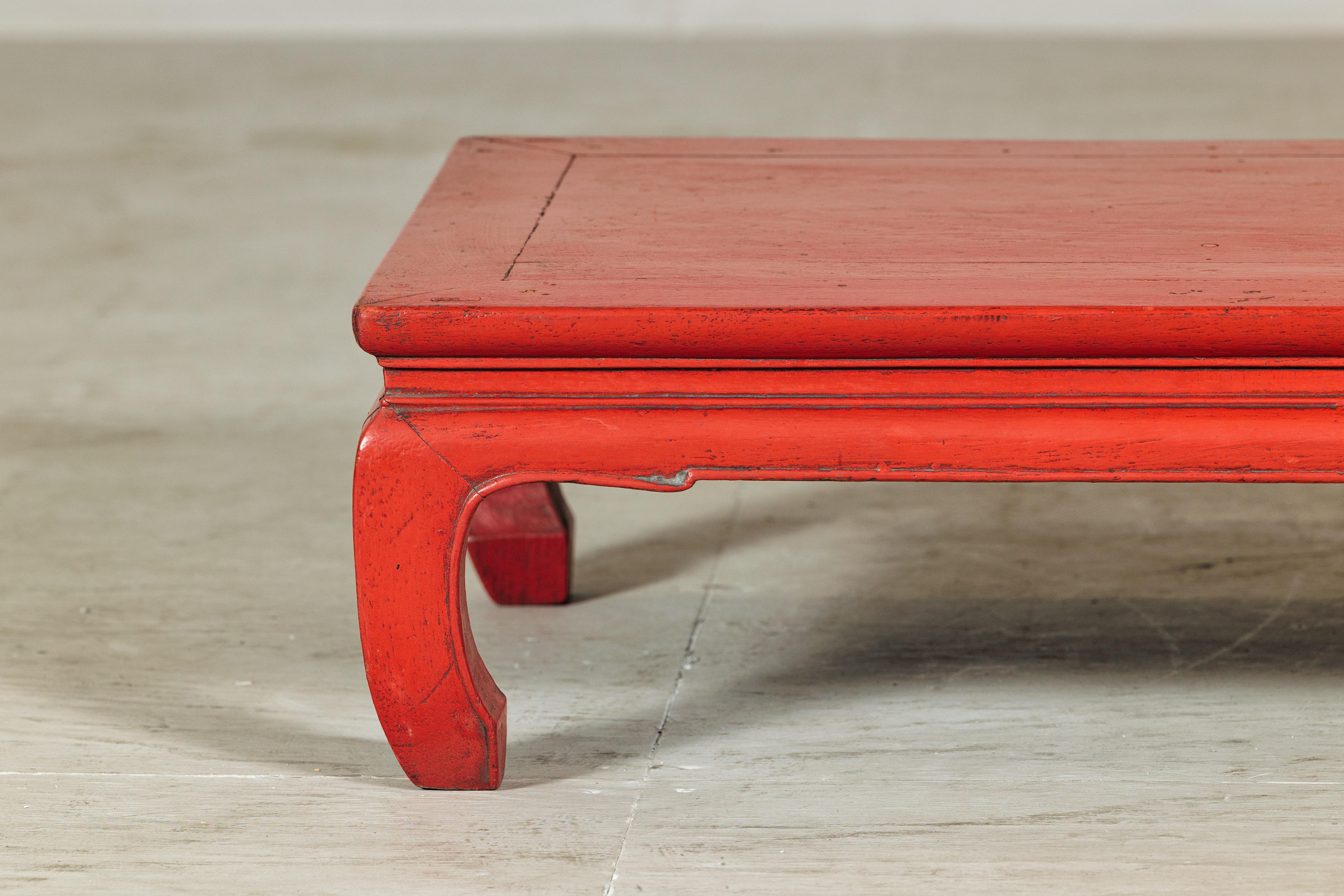 Ein chinesischer Vintage-Tisch mit roter Lackierung und geformter Schürze aus dem 20. Jahrhundert, ideal als Couchtisch. Mit seinen kompakten Proportionen und seinem warmen Farbton präsentiert dieses Stück eine zurückhaltende Eleganz, die im