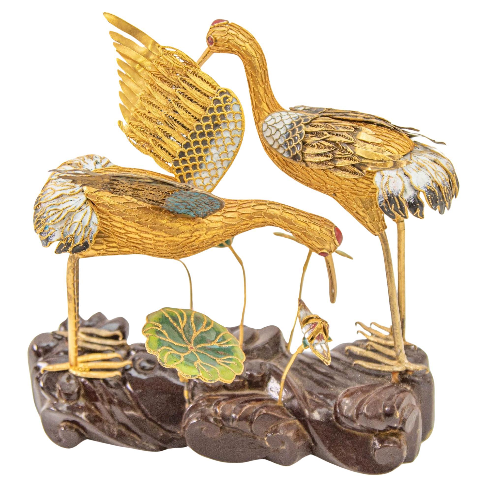 Figuras chinas vintage de metal dorado con filigrana y grullas esmaltadas sobre soporte de madera