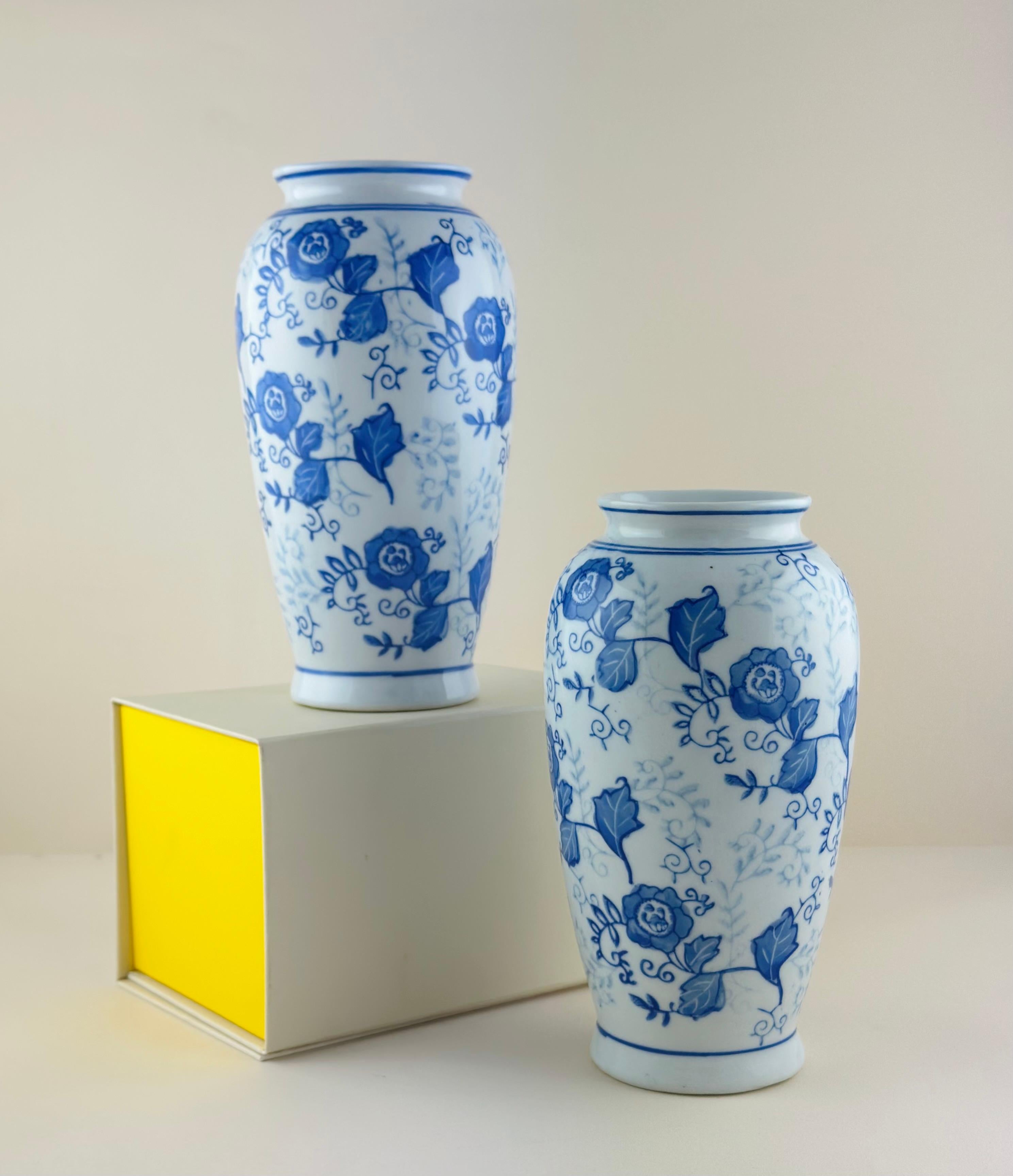 Pair of vintage 'Ming style' vases, crafted in China around the late 1980s.

Delicately hand-painted and glazed with a Ming-style decoration: A trail of bold cobalt blue flowers and delicate foliage, covers the body of these ''Hu'-shaped vases. The