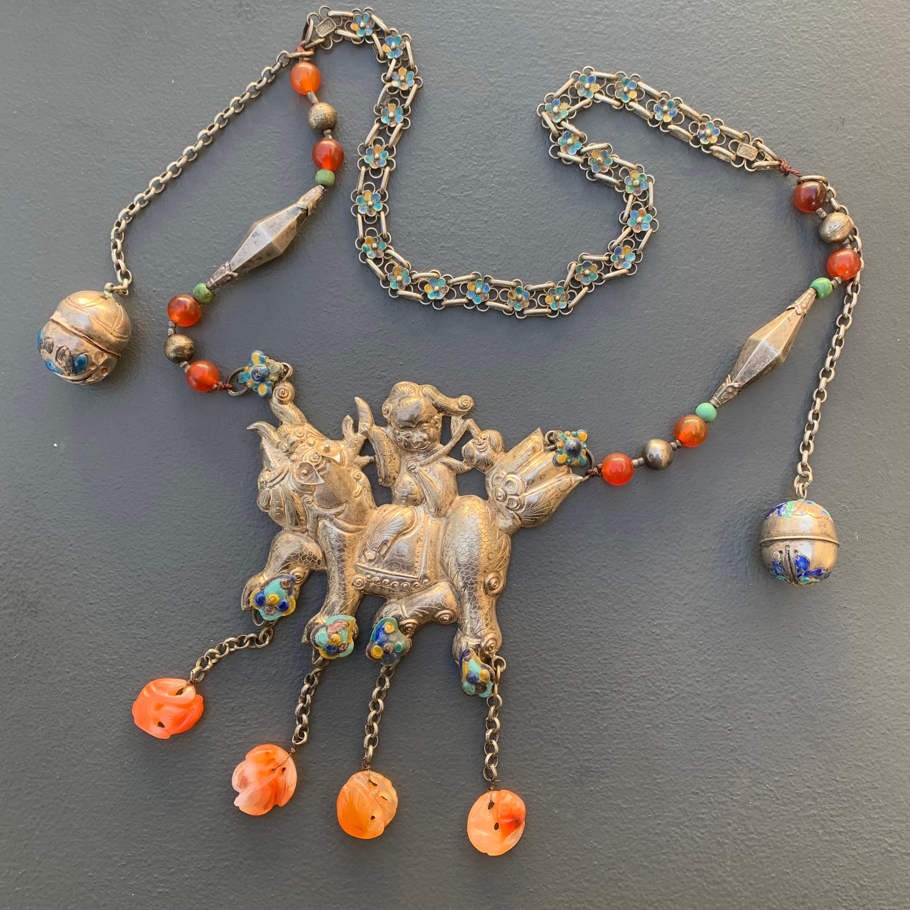 MASSIVE Old Chinese or Mongolian Silver statement necklace with a large stamped  pendant featuring a boy riding what looks like   guardian lion . Necklace chain is  made of  carnelian  , turquoise beads and conical  silver bead in between and a
