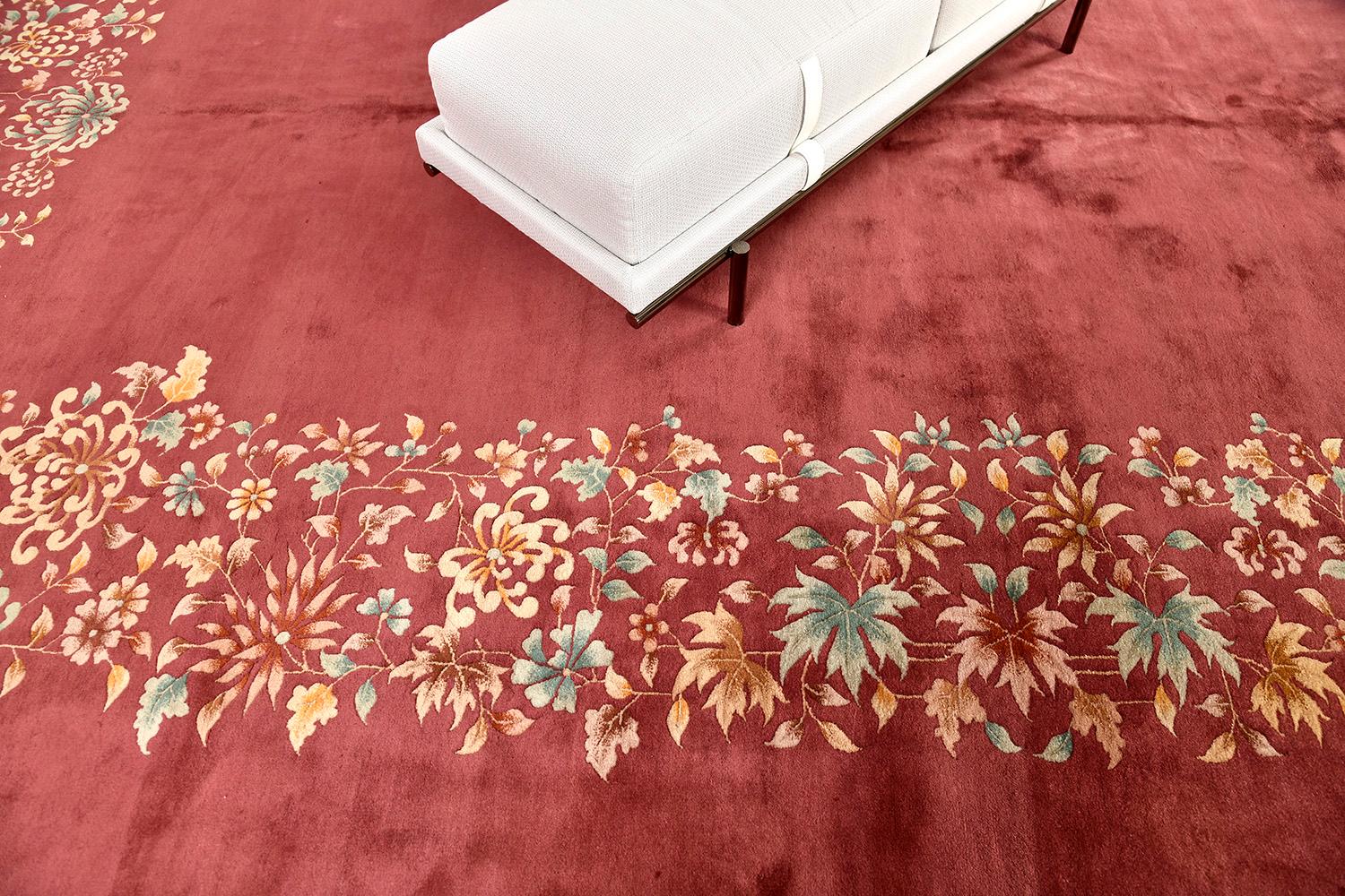 A vintage Nichol Chinese art deco rug that will leave lasting impressions and elevate any design space. The bold elegant blushing field and full bloom borders together with the traditional floral vines work to create a vibrant and fashionable