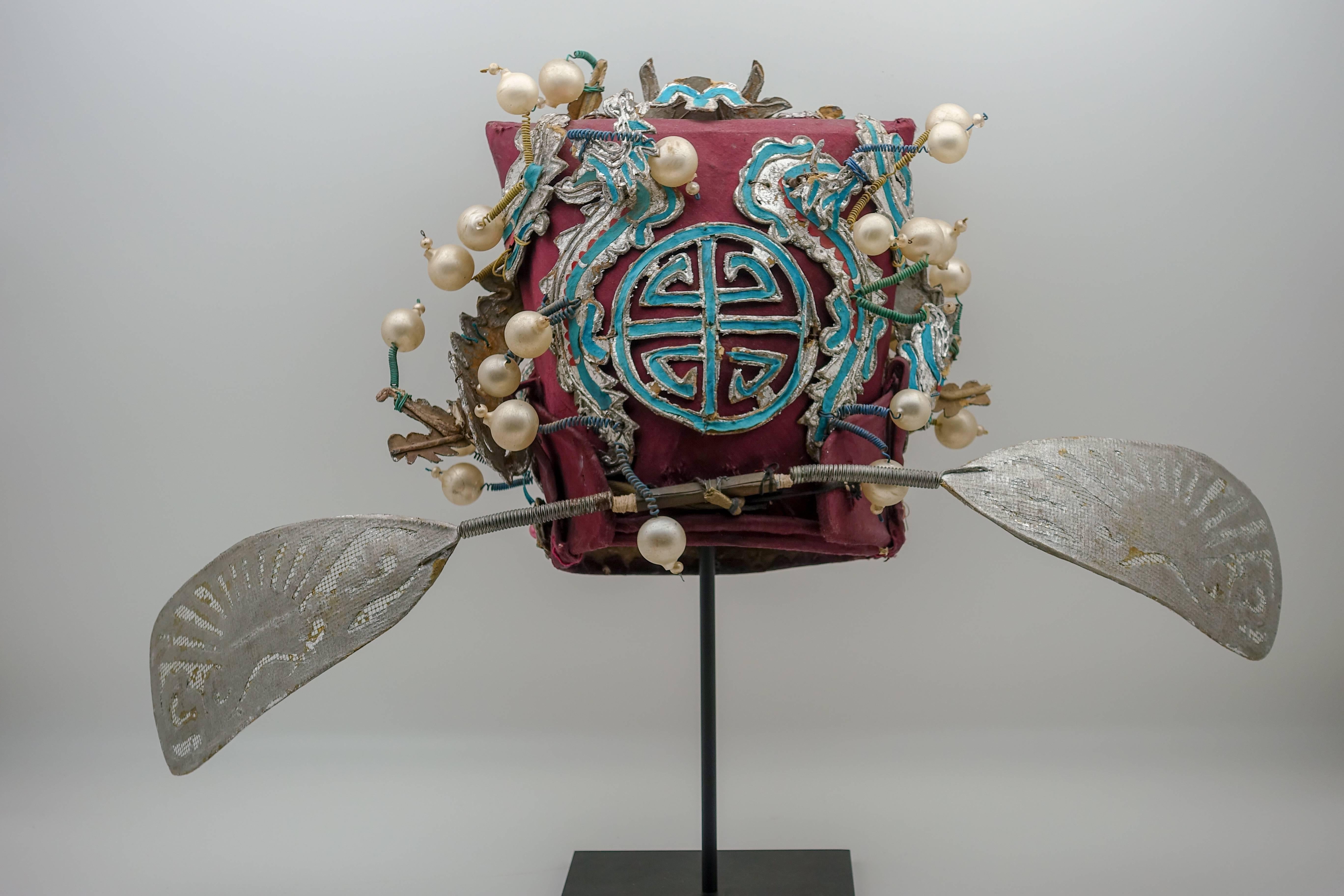 Vintage Chinese opera theatre headdress in turquoise, ox blood and silver colors with faux white and pink pearls, early 20th century, mounted on a custom, black painted metal base.