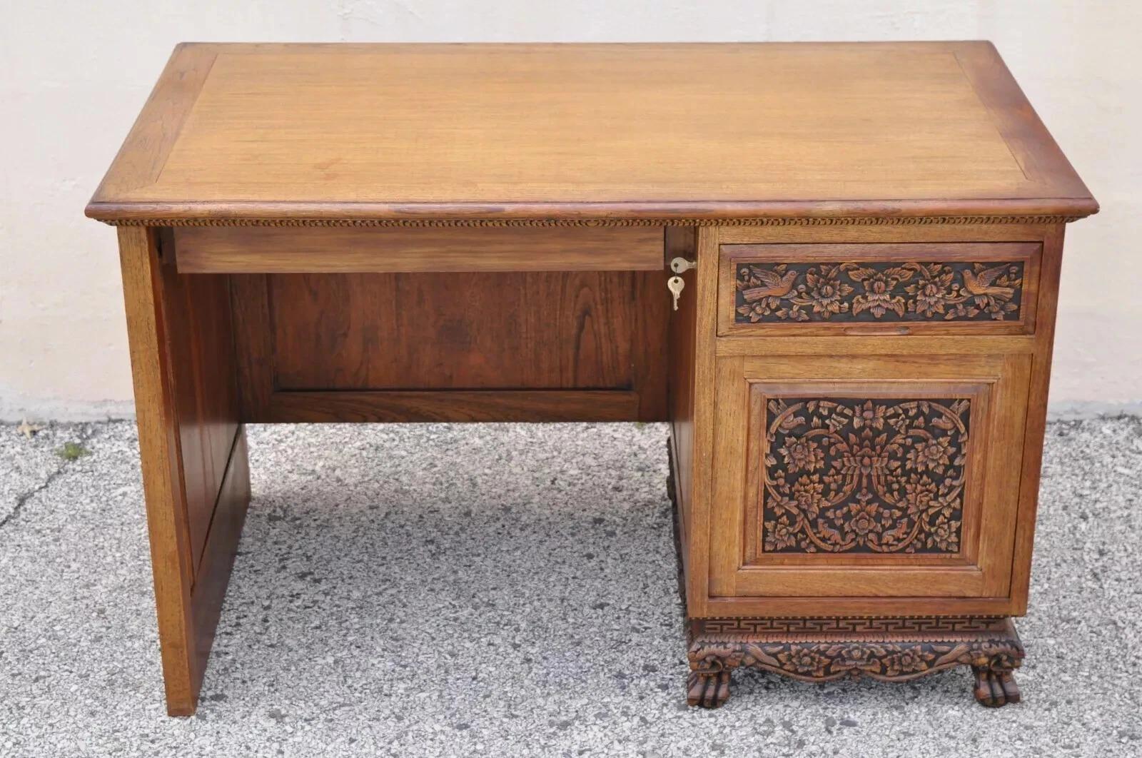Vintage Chinese Ornately Carved Mahogany Oriental Chinoiserie Office Desk. Item is ornately carved throughout with flowers, birds, and leafy scrollwork, carved faces to feet/base, 1 swing door, working lock and key, and 3 dovetailed drawers. Circa