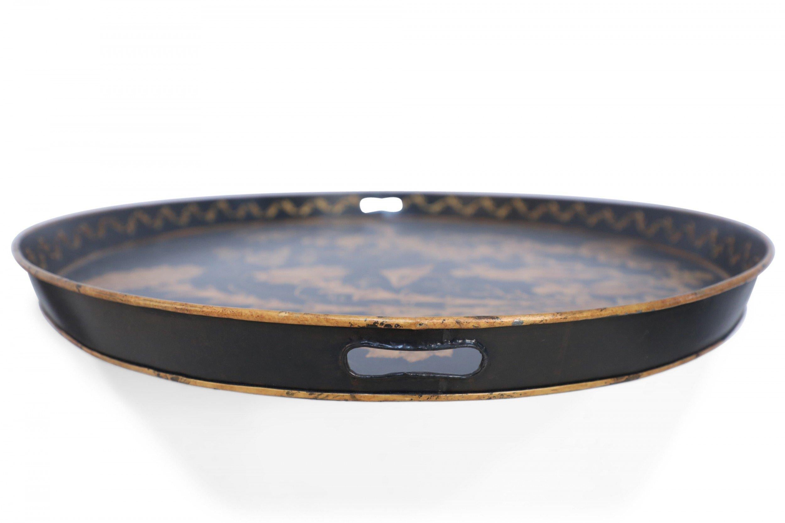 Vintage Chinese oval tole serving tray with a painted gold design of a figures climbing a staircase to a walkway surrounded by flowering plants on a black background with a shallow lip with two cut out handles.
 