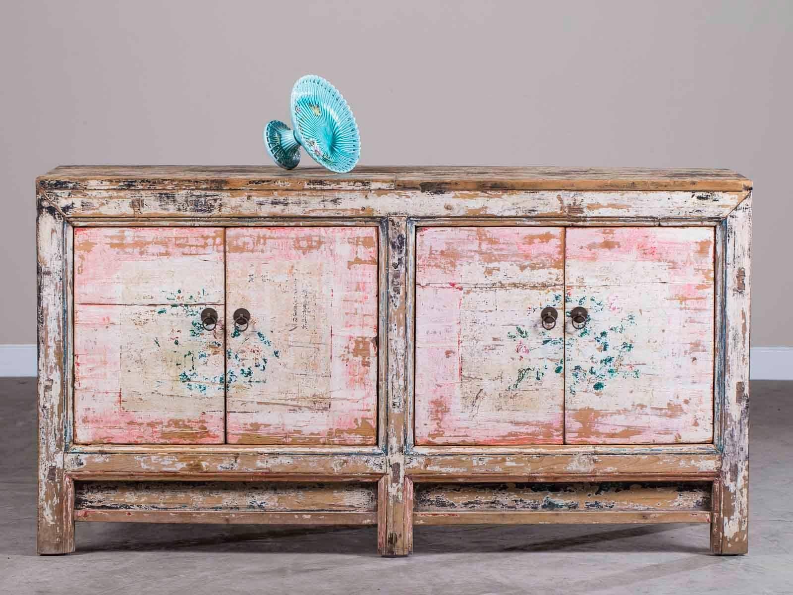 A vintage Chinese painted four-door buffet in pink and black, circa 1940. The beautiful painted finish on this Chinese buffet combines both black and pink along with faded remnants of flowers across the four cabinet doors. The modern quality of the