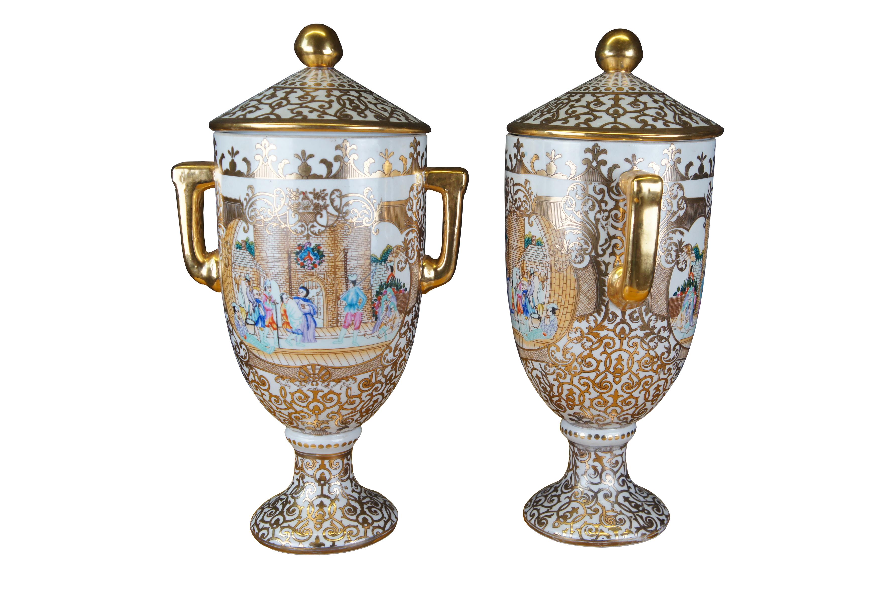 Beautiful pair of late 20th century Chinese porcelain buffet urns. Each features a white base with gold trim and central medieval castle landscape scene. Shaped in classical trophy urn form with handles and lid. Marked along underside.