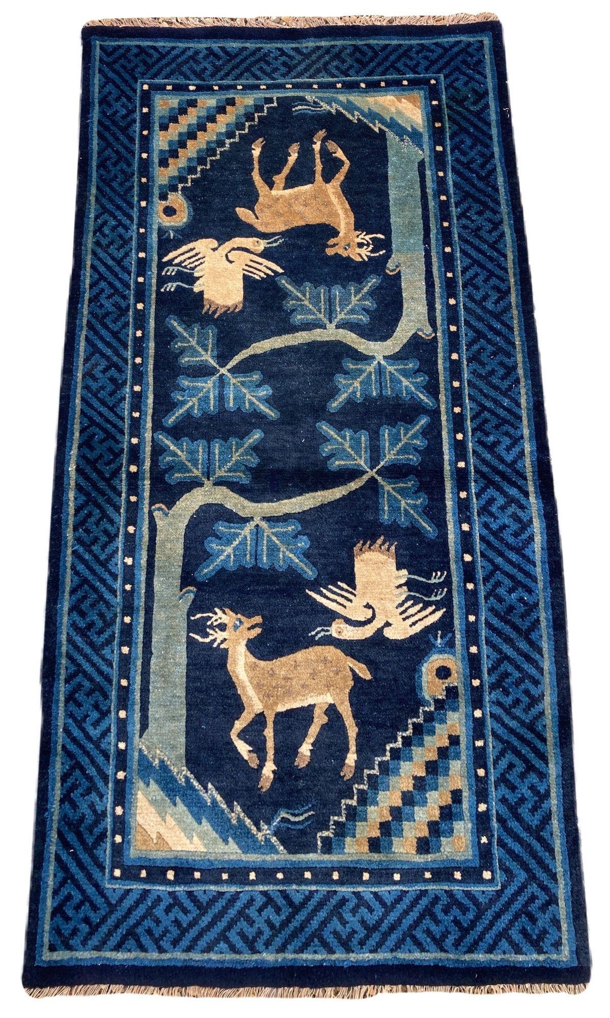 A lovely vintage Pao-Tao rug, handwoven in China circa 1940 with the traditional design of the deer and the crane on a deep indigo field and key border.
Size: 1.32m x 0.71m (4ft 4in x 2ft 4in)
This rug is in good condition with light age related