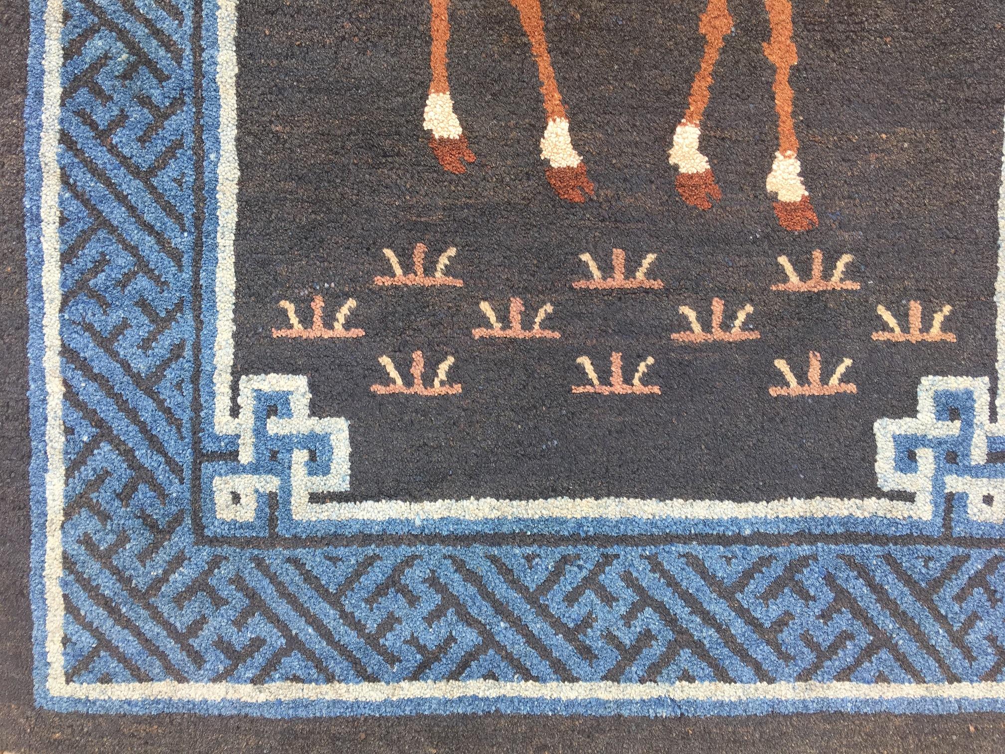 A beautiful Pao-Tao rug, handwoven in China, circa 1940 with a pictorial design featuring a red crane above a spotted deer, both symbols of longevity, on a navy blue field. Measures: 1.49 m x 0.66 m.