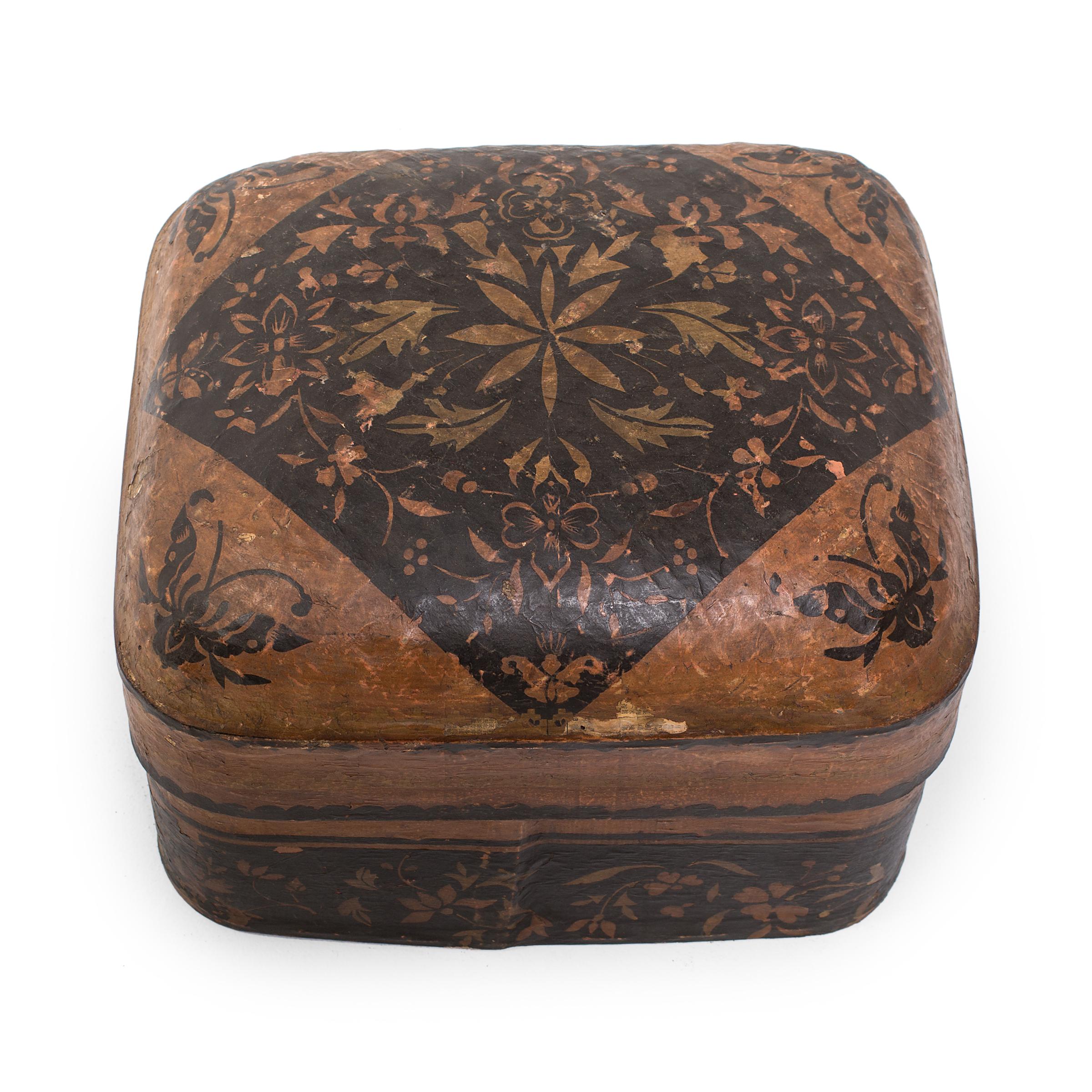 Formed around a simple wooden frame, this papier mâché storage box is a delightful example of Chinese Folk Art. Crafted with old newspapers and dyed rice paper, the box would have been used for basic household storage. Delicate black paper cuts