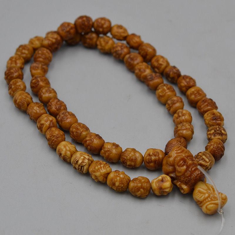Collier chinois vintage sculpté de têtes d'arhats en pierre de pêche en vente 1