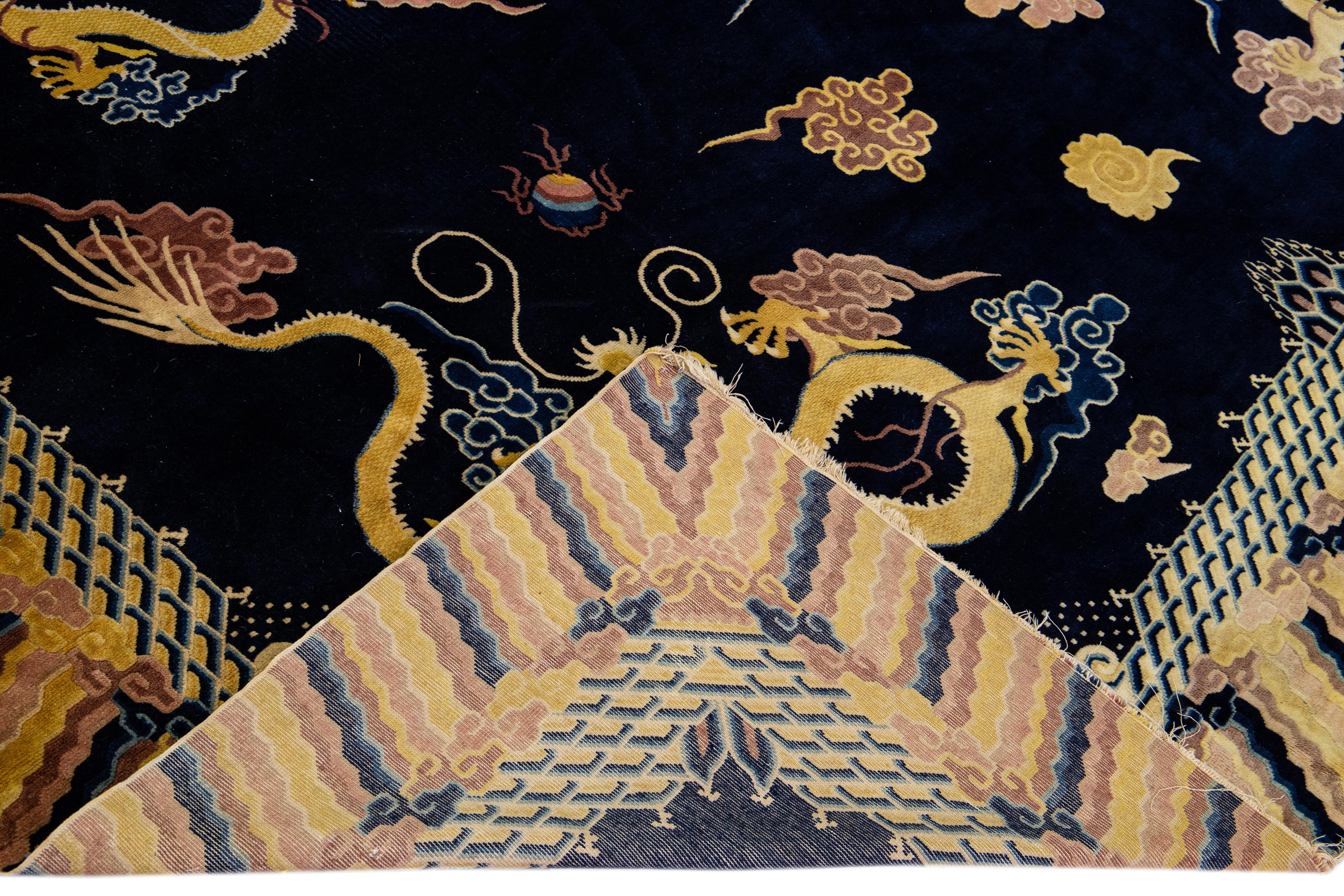 Magnifique tapis chinois ancien en laine nouée à la main, avec un champ bleu foncé et des accents multicolores sur l'ensemble du motif traditionnel du dragon chinois. 

Ce tapis mesure 9'10