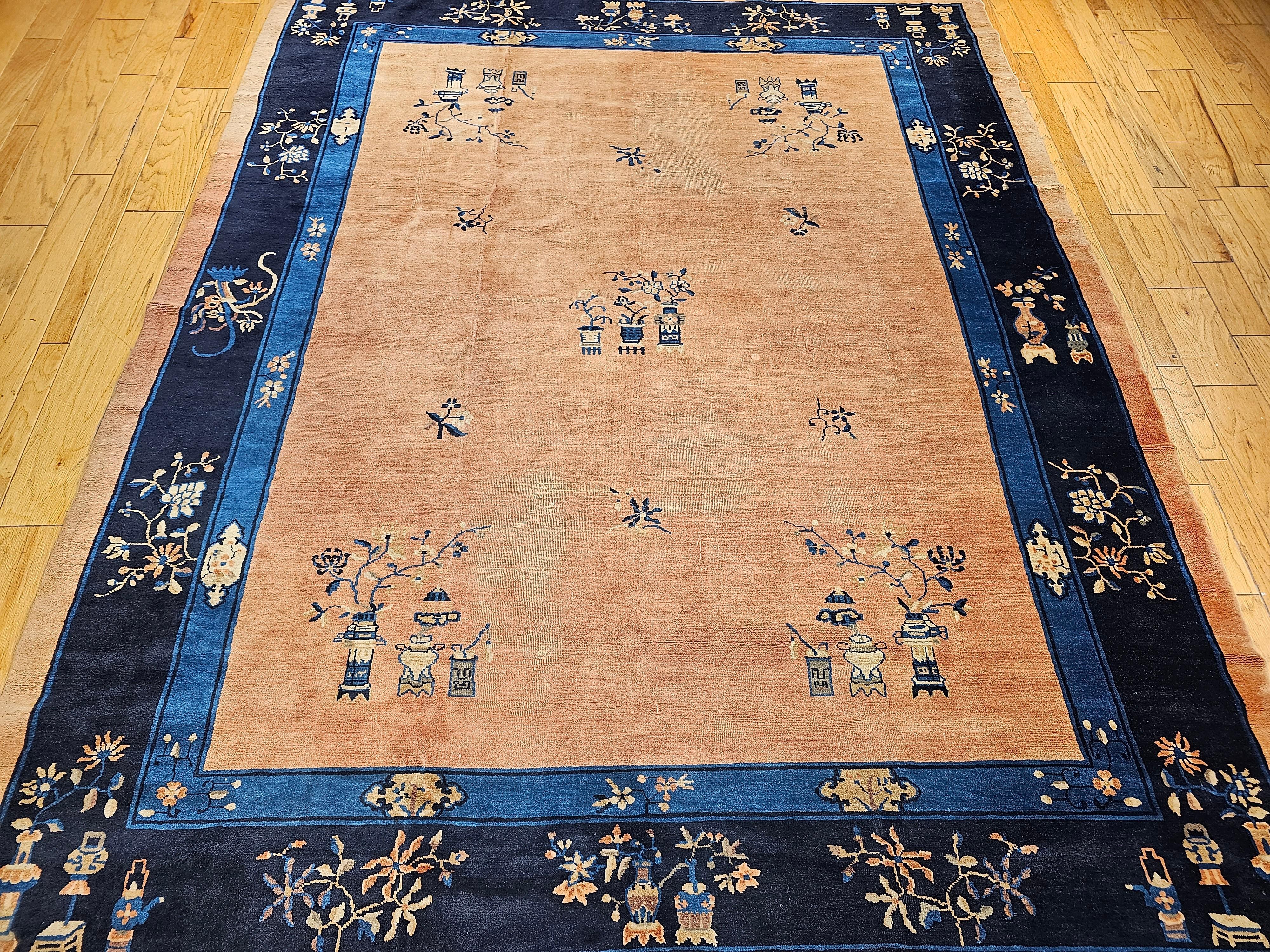 Vintage  Tapis chinois de Pékin noué à la main de la fin des années 1800.  Le tapis a un champ de couleur pêche pâle avec des bordures bleu marine et bleu pâle.  Le tapis présente un magnifique et subtil motif floral chinois classique.  Les tapis