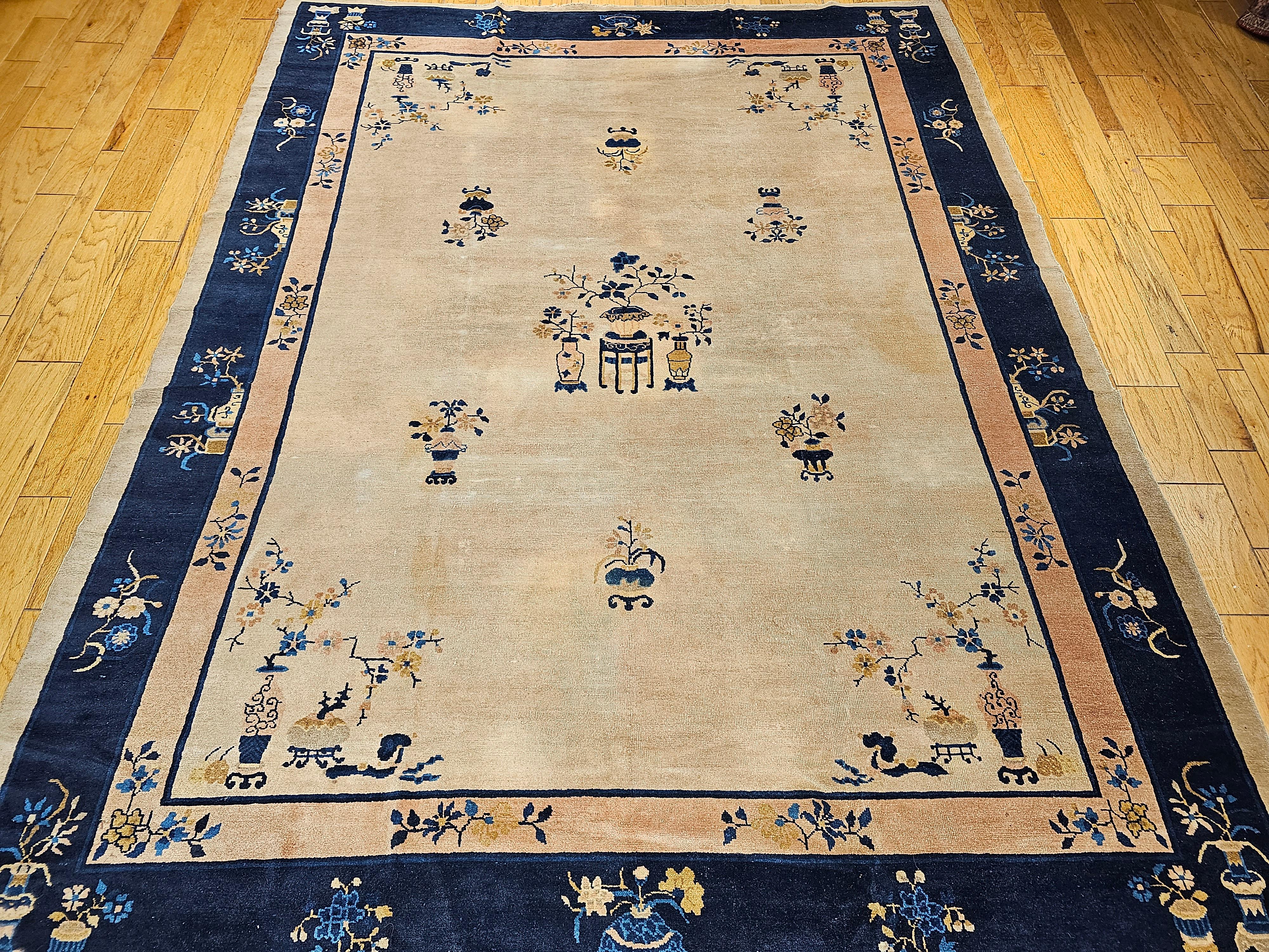 Beautiful Chinese Peking rug from the late 19th century with pale yellow/tan field color and border in blue and pale peach/pink border.  The Chinese Peking rug has the traditional flower vase design in the border and on the corners.   The Chinese