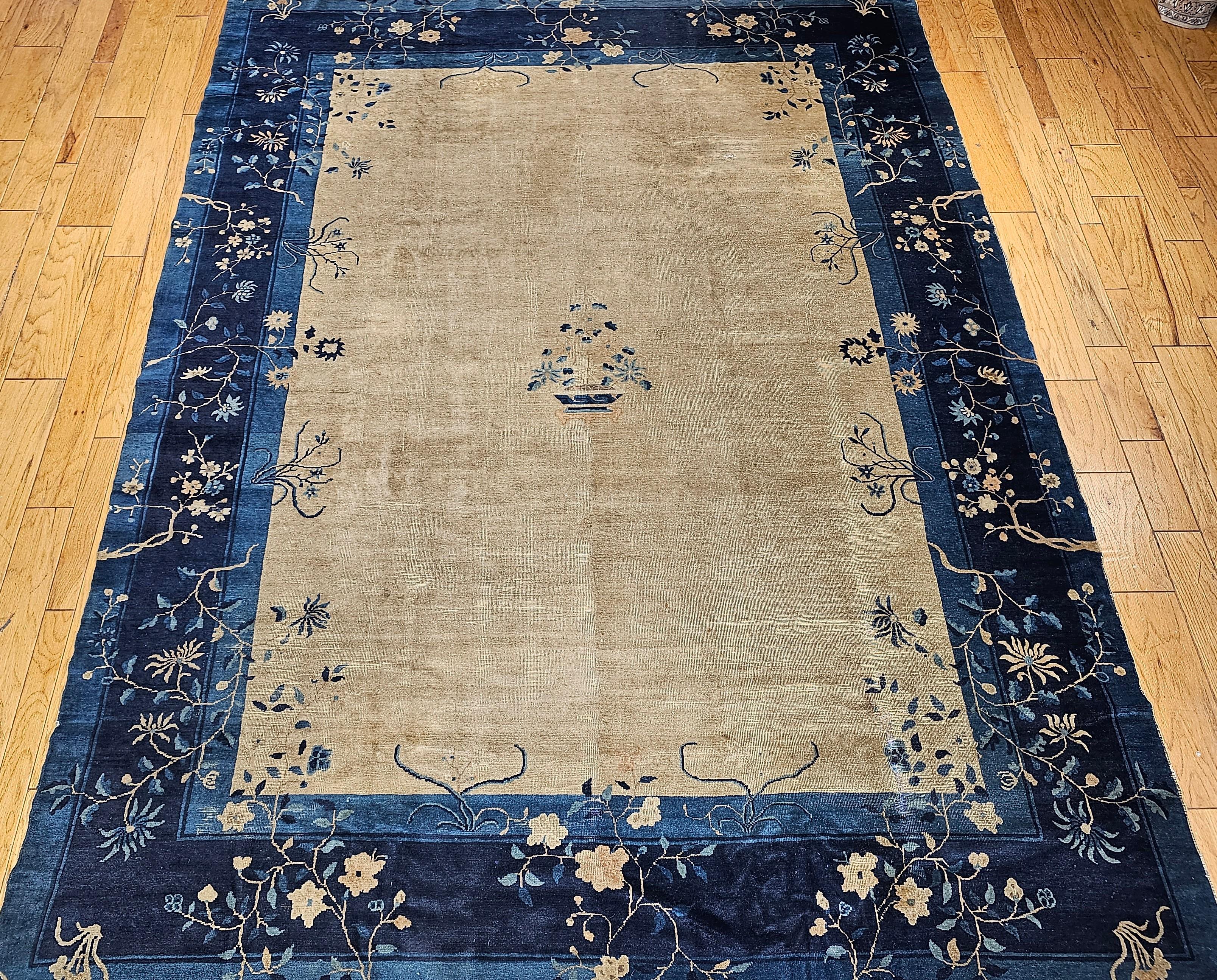 Vintage Chinese Peking room size rug is from the late 19th century.  It has a beautiful natural straw/gray color in the field framed by two shades of blue(Navy and French blues) in the border. This beautiful simple and serene design in this Chinese