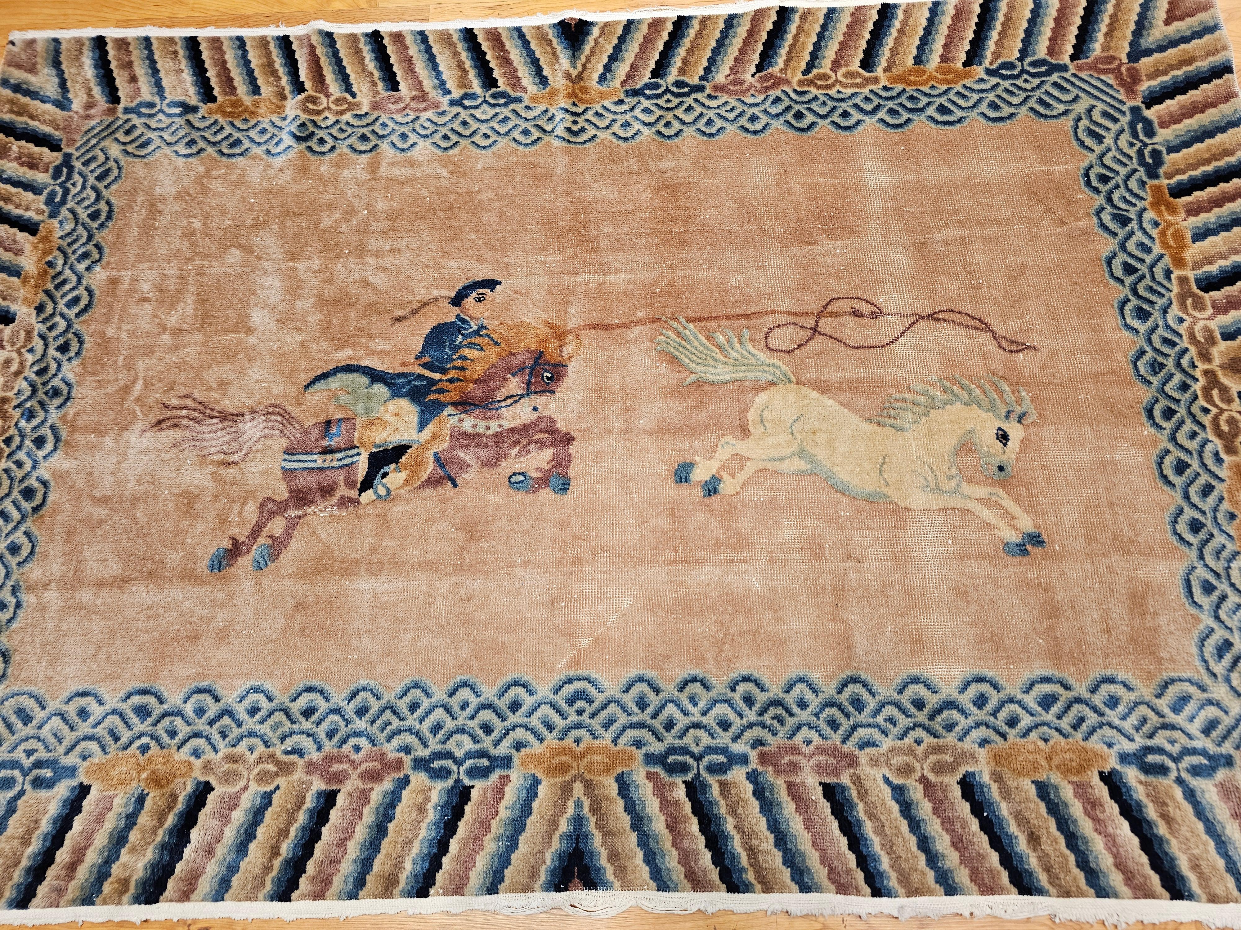 Dieser chinesische Bildteppich im Vintage-Stil fängt einen eindrucksvollen und dynamischen Moment ein: einen Reiter in Aktion, der gekonnt eine Seilschlaufe schwingt, um ein wildes Pferd in Bewegung zu halten. Die Szene steht vor einem ruhigen,