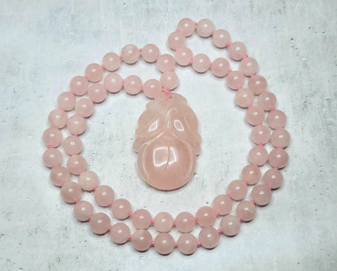 Un collier vintage de propriété en quartz chinois rose naturel sculpté avec pendentif et perles. Le pendentif en quartz est taillé en forme de fruit et est enfilé sur un fil de soie rose avec des perles de quartz de haute qualité. Le pendentif en