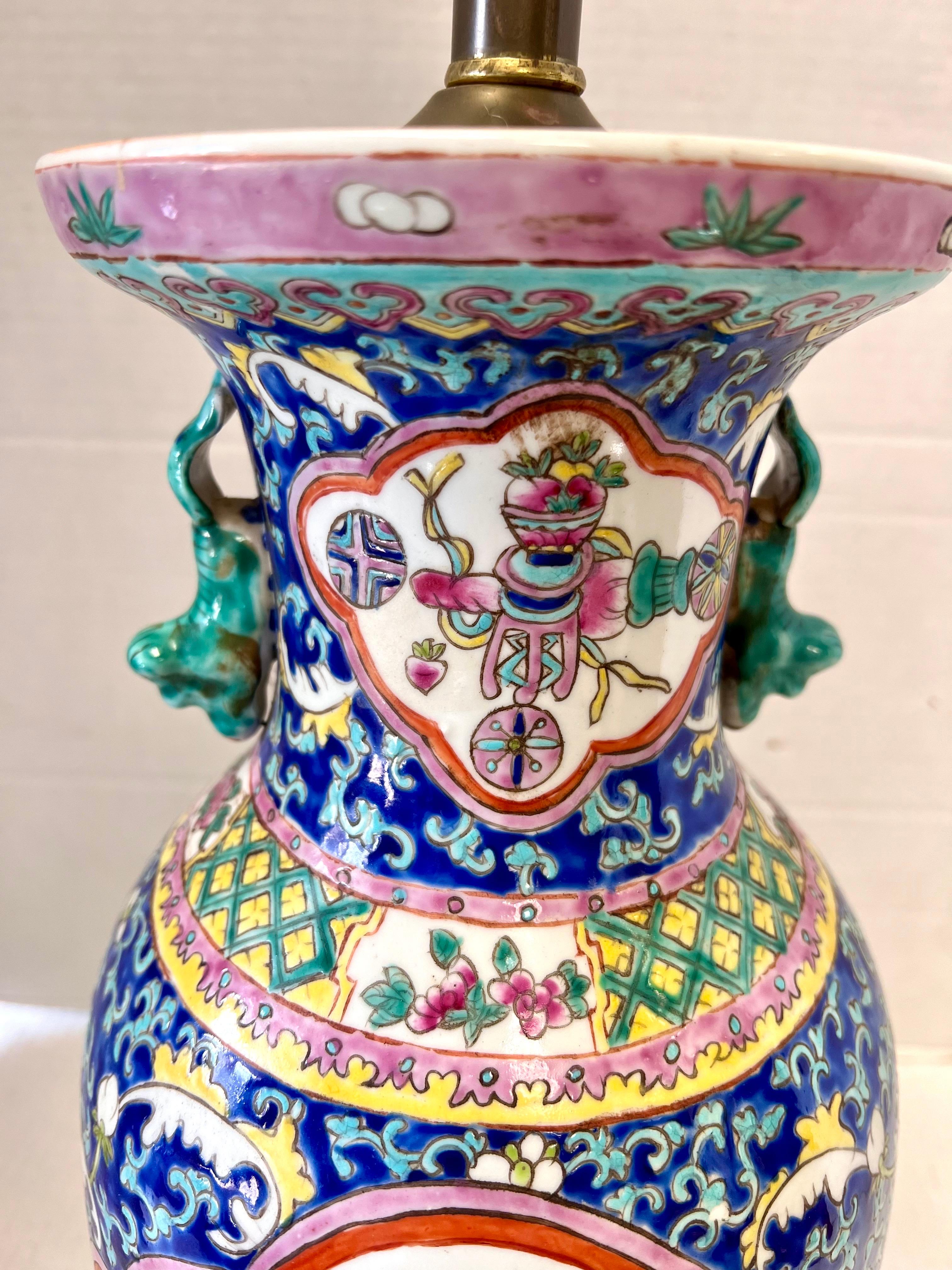 Stunning Chinese porcelain table lamp features hand painted floral motif on a blue ground with applied turquoise foo dog handles. Wired for US and in working order. Comes as shown with no shade or harp.