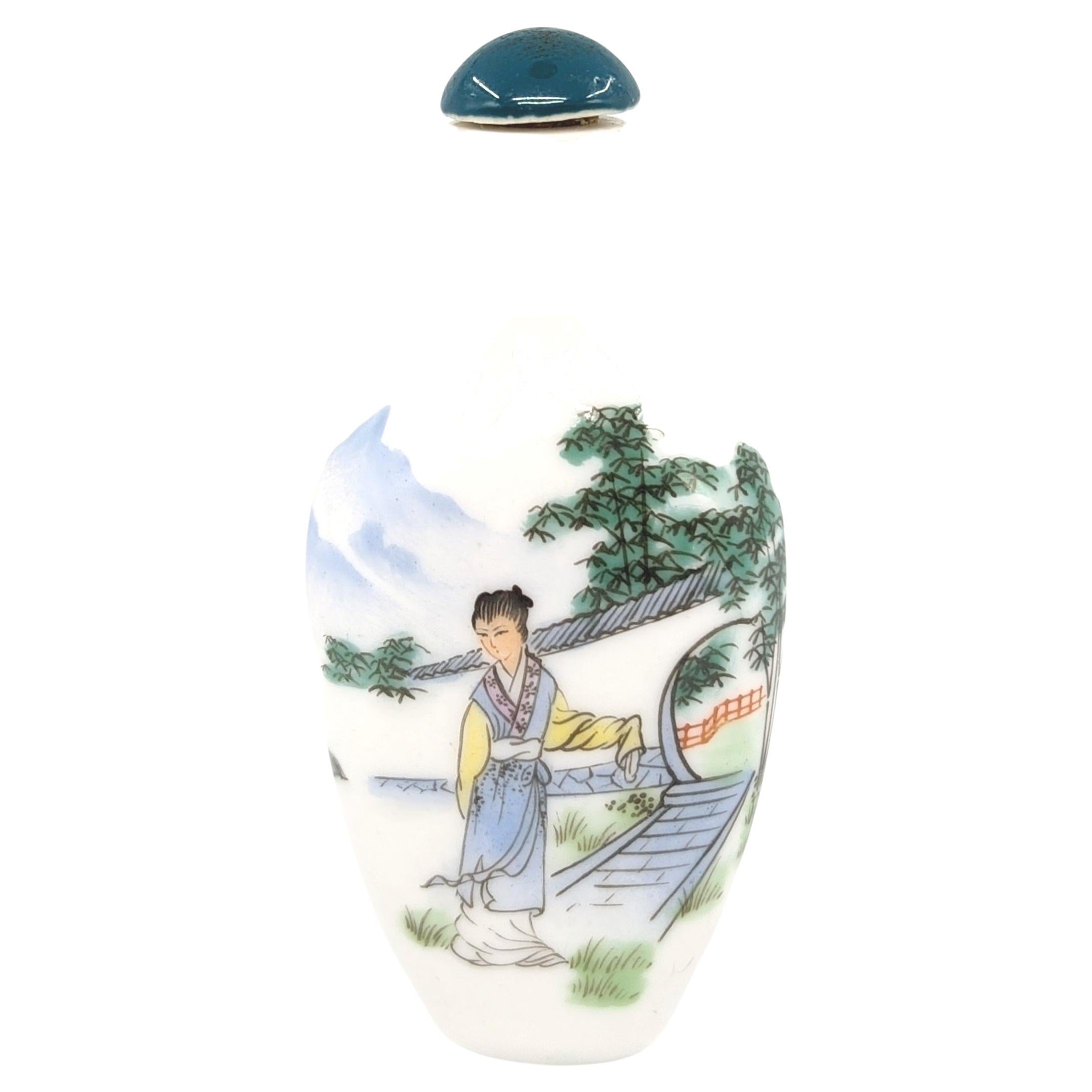 A vintage Chinese porcelain snuff bottle, hand painted with a beauty in a courtyard setting on each side, and signed “癸丑年” （