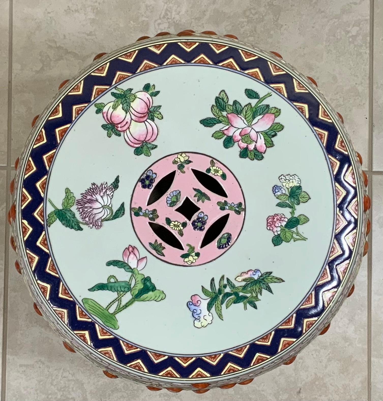 Beautiful Chinese porcelain garden stool of traditional drum shape, stunning colors of Chinese scenery of garden flowers and Chinese motifs all around, and the top. With three intricate exceptional borders one at the top and one at the bottom and