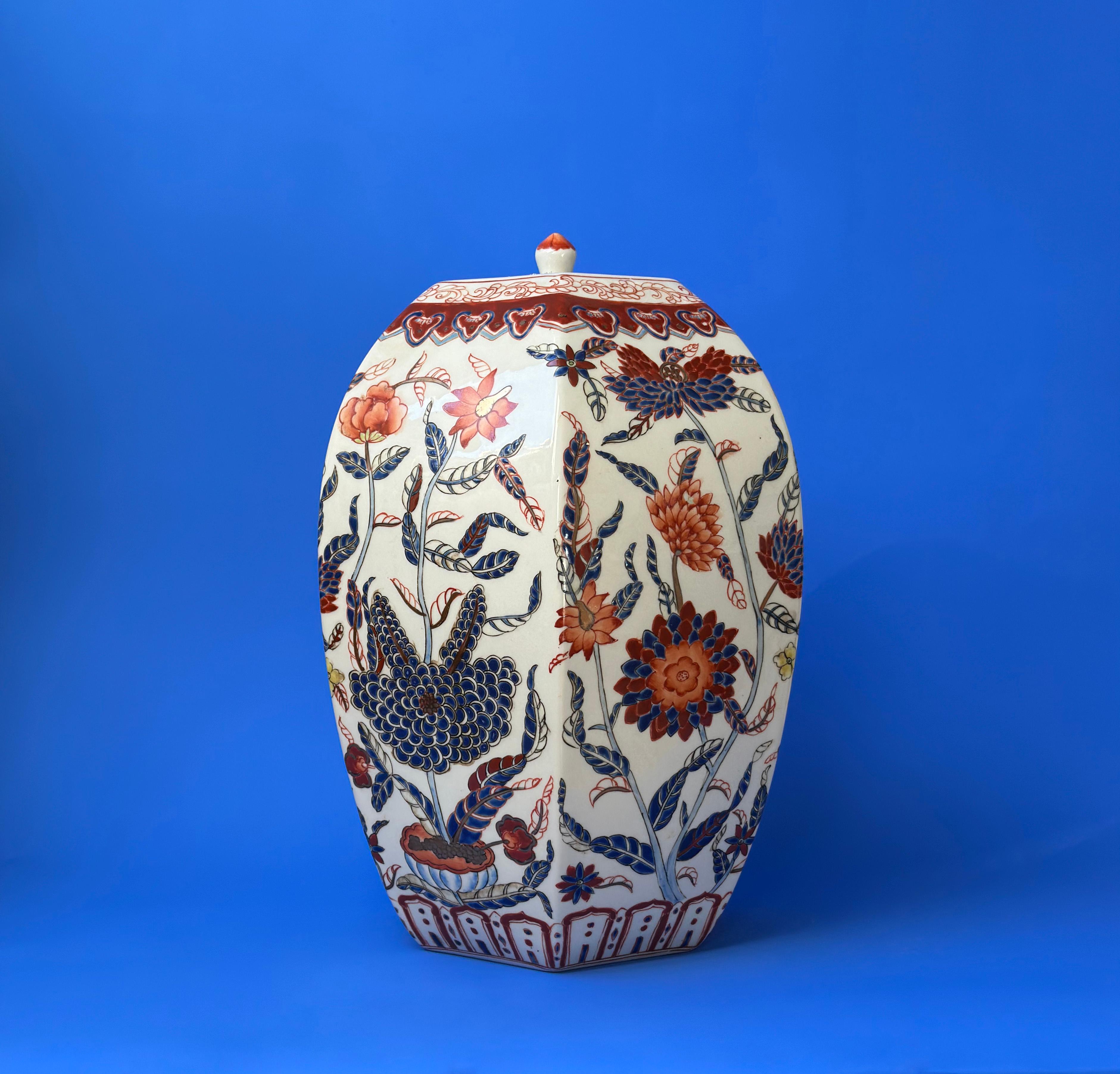 Chinese Porcelain Urn - Vintage 

This large, hexagonal lidded urn is a masterpiece of fine Chinese porcelain. It is meticulously adorned with an elaborate array of floral motifs in red and blue, which gracefully extend upwards and around the urn's